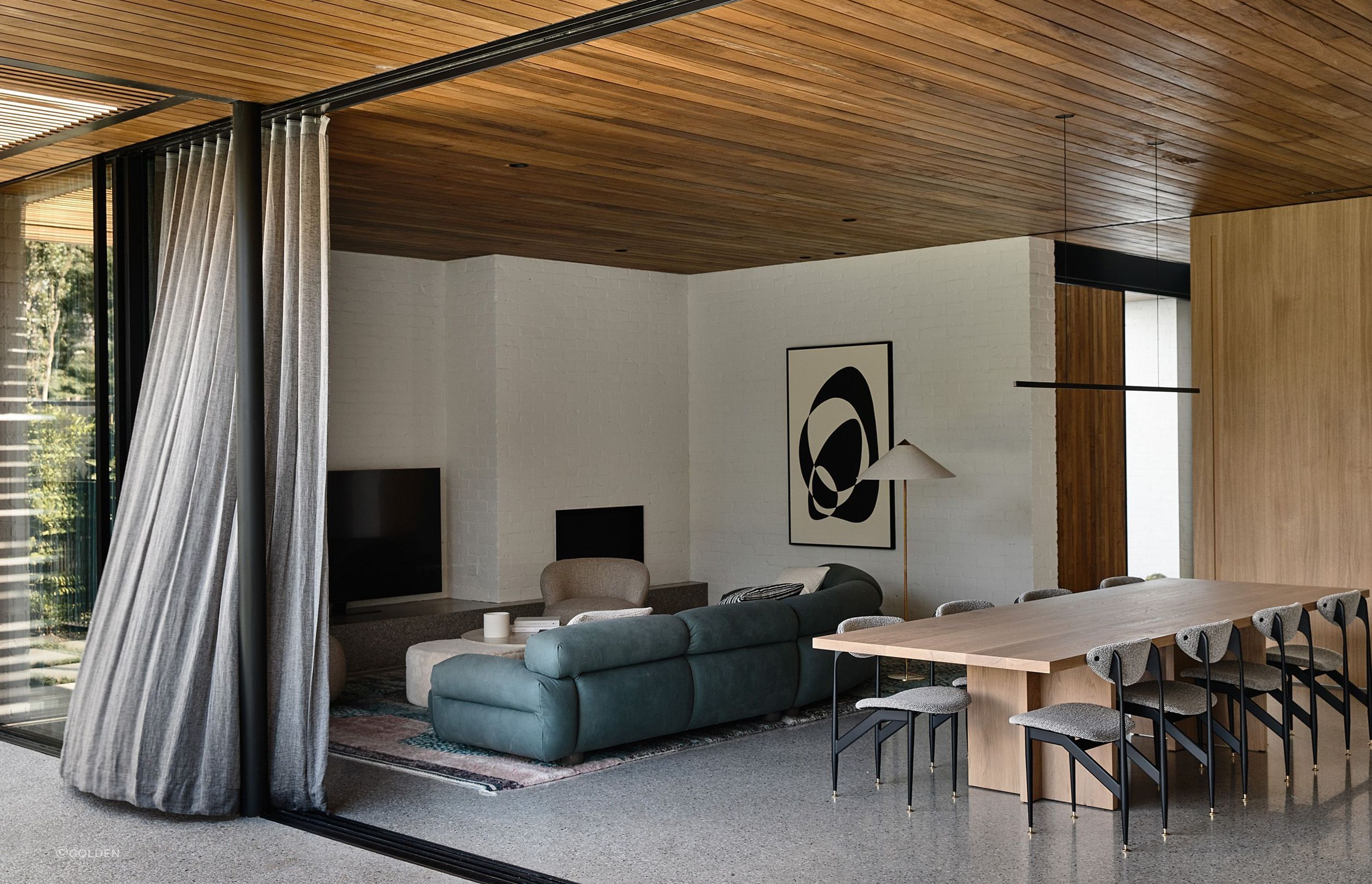 Teak ceilings, large oak doors and wall panels add warmth to the interior and contrast beautifully with the concrete floors in this mid-20th century inspired home - Photography: Derek Swalwell