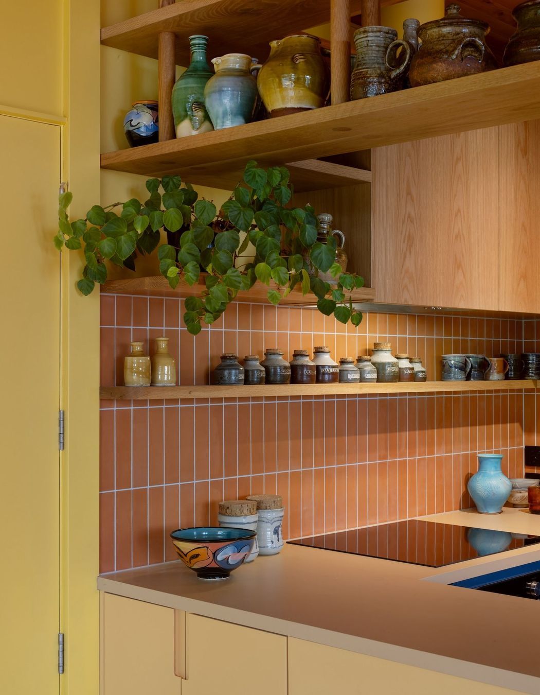 Interior Design and Architecture by Chris Corson-Scott and Pac Studio Oak shelving detail and custom cabinetry paired with the artist's collection of handmade kitchen pottery objects and vessels including pieces by Andrew Van Der Putten, Len Castle and Peter Lange