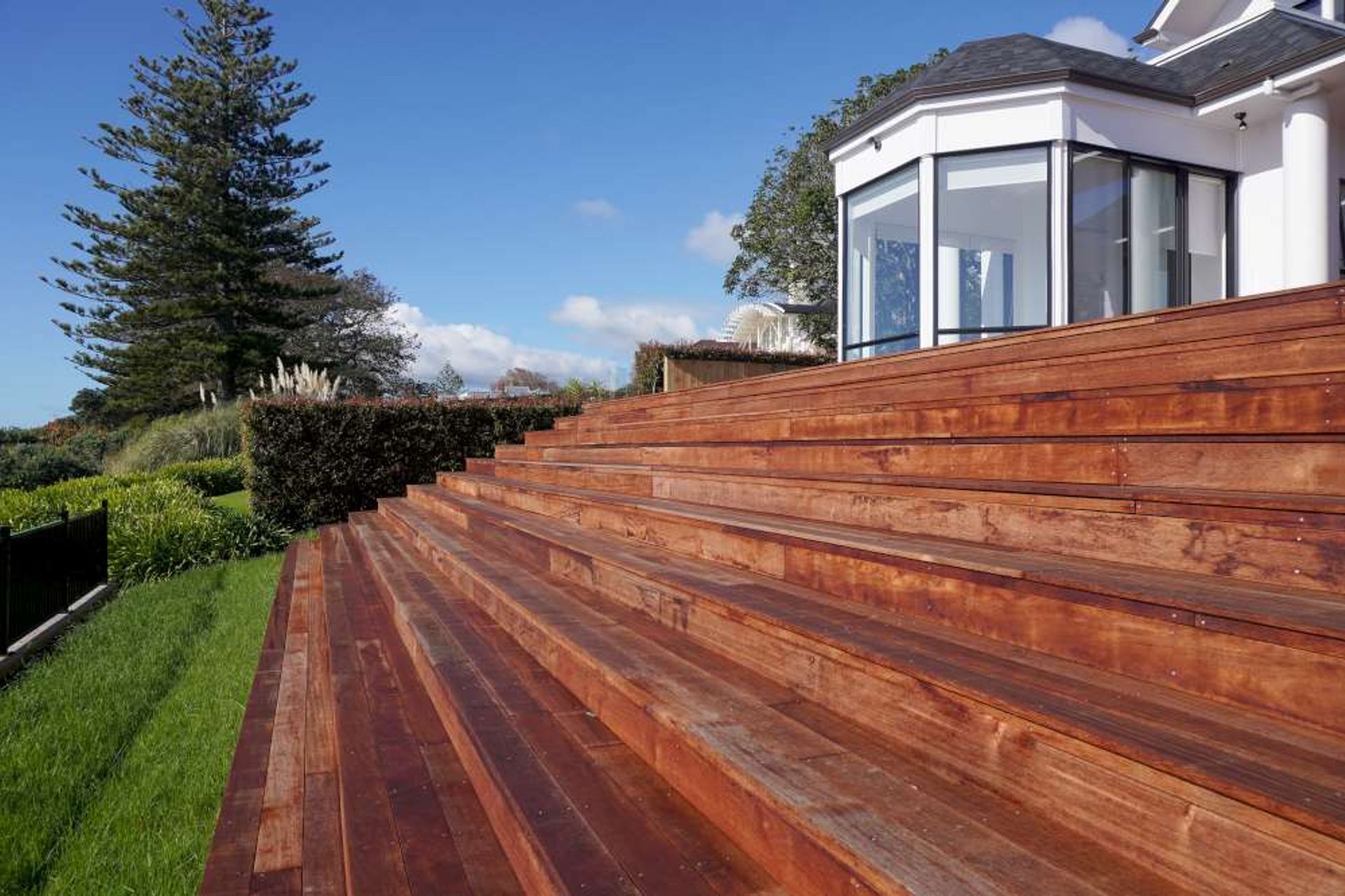 This landscaping project involved creating a large Kwila Deck around the house with the front section going down in stairs leading to a small lawn area that was fenced with aluminium fencing providing spectacular views of the Mellon’s Bay in Auckland