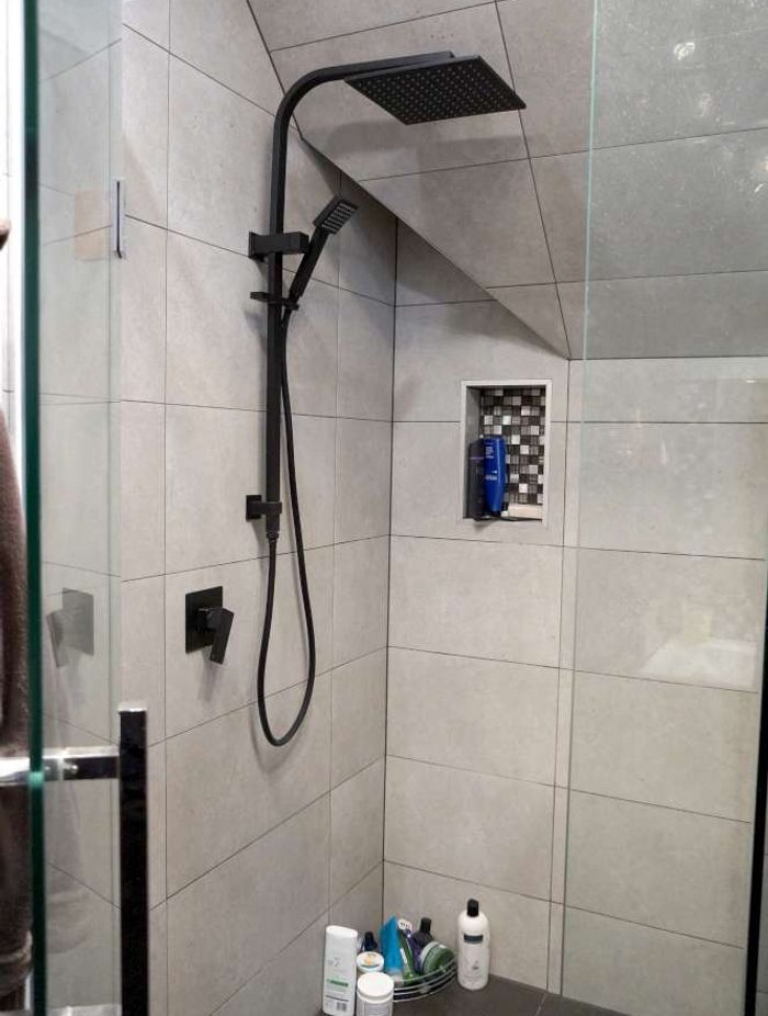 Bathroom renovation in Cockle Bay, Auckland. A shower niche was created in the wall of the tiled shower as a design feature.