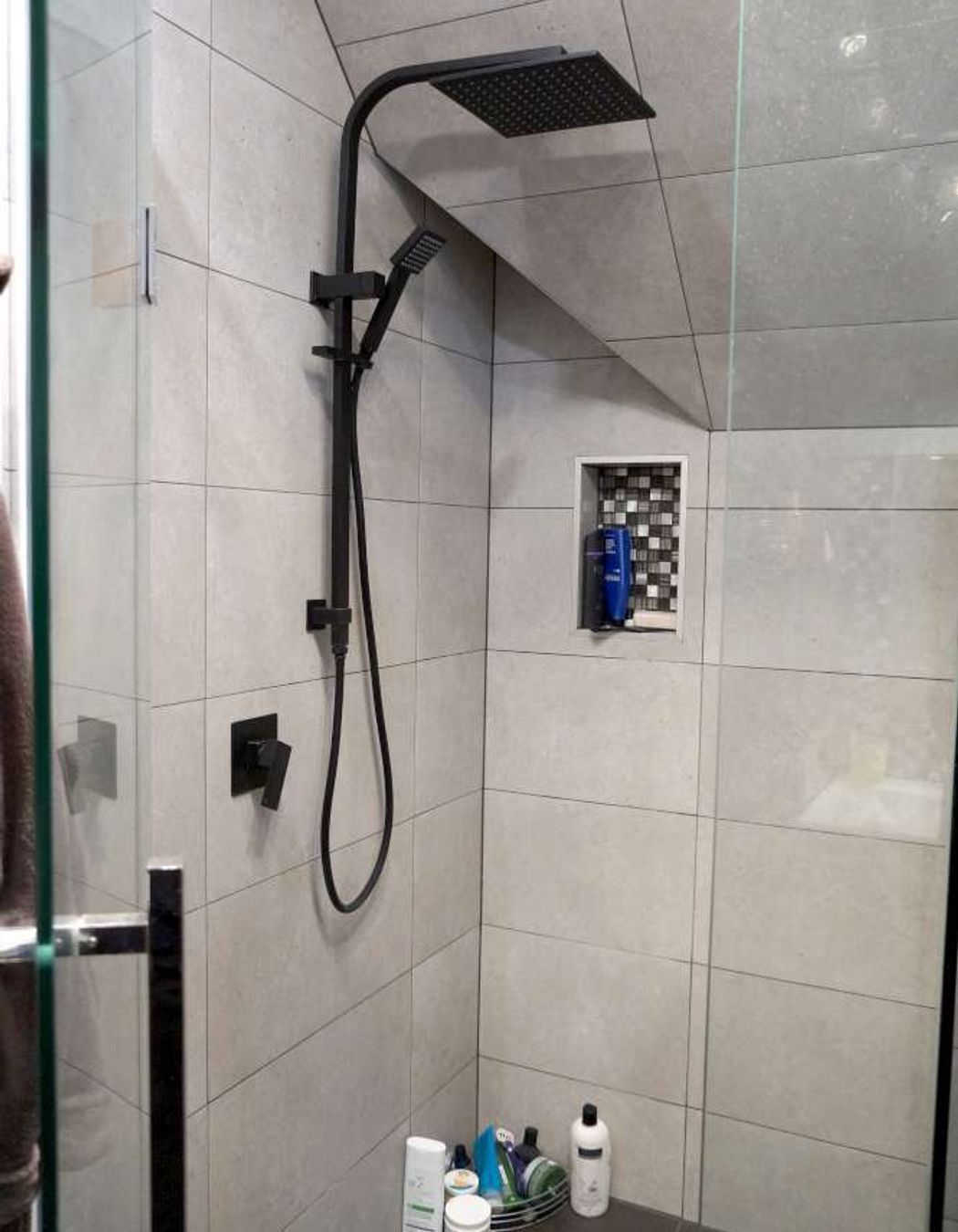 Bathroom renovation in Cockle Bay, Auckland. A shower niche was created in the wall of the tiled shower as a design feature.