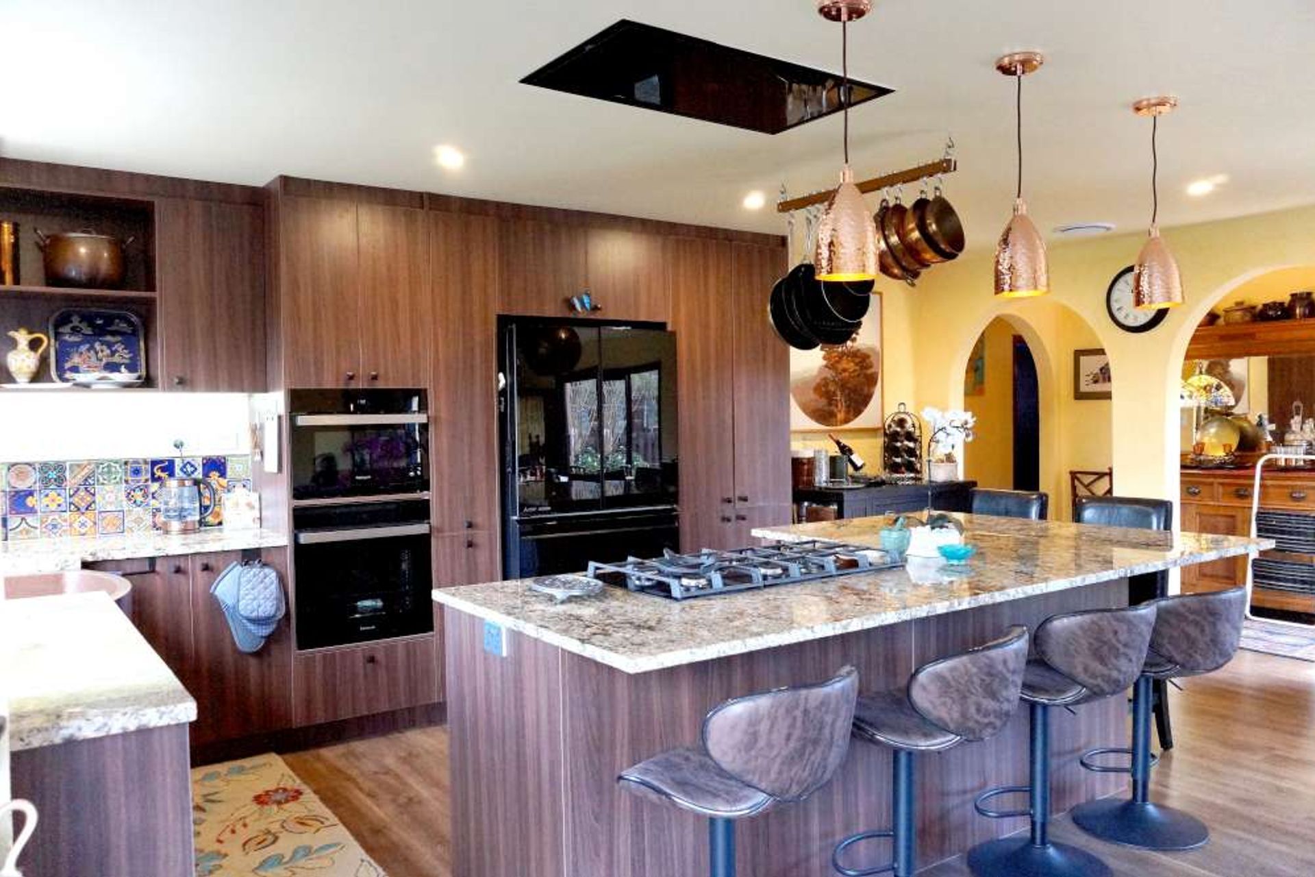 L Shaped Kitchen from our Stanmore Bay renovation with a large island with  bar stools and a hob