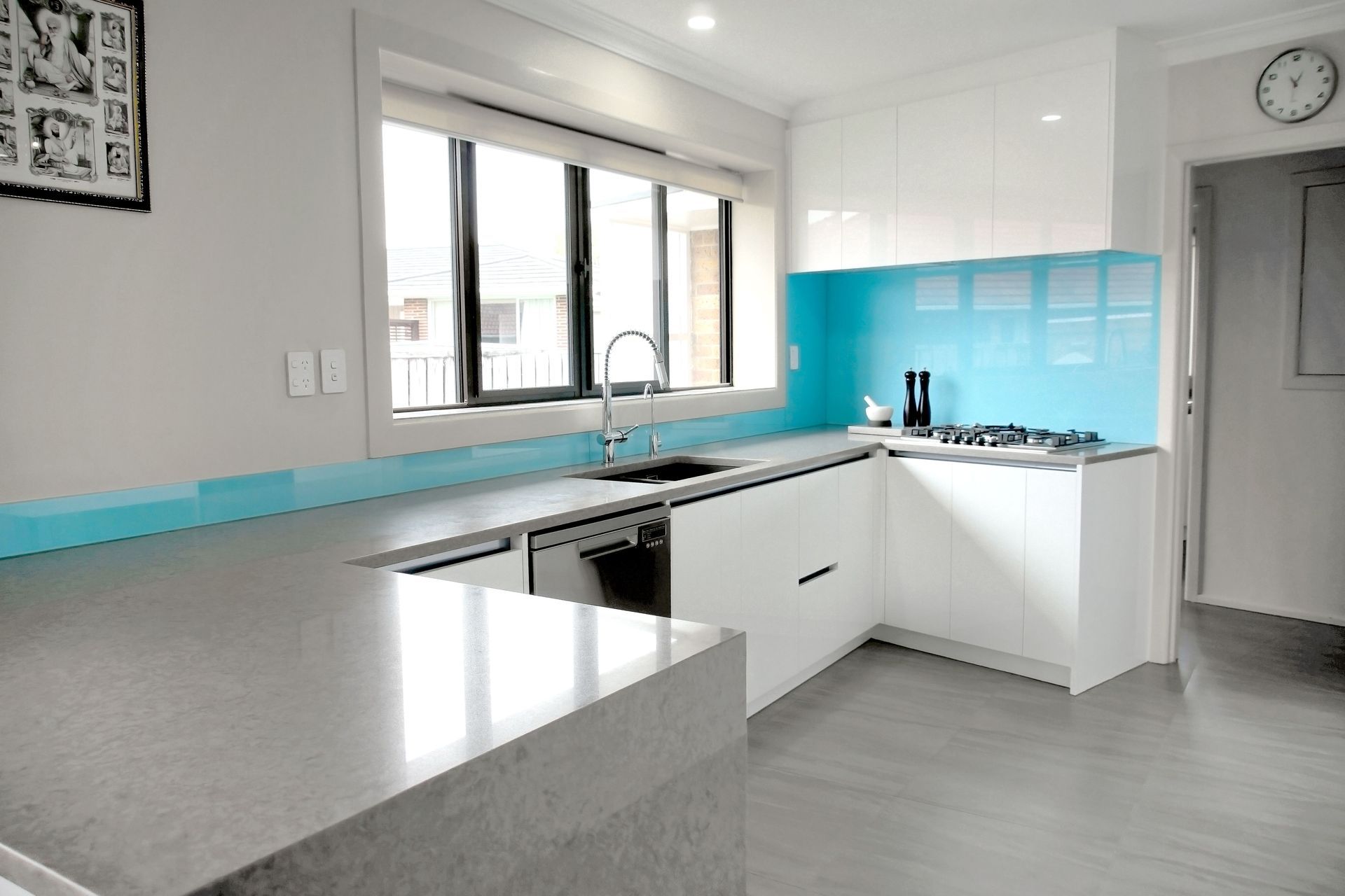 A sky blue backplash was added to add some colour into a neutral themed kitchen in Papatoetoe