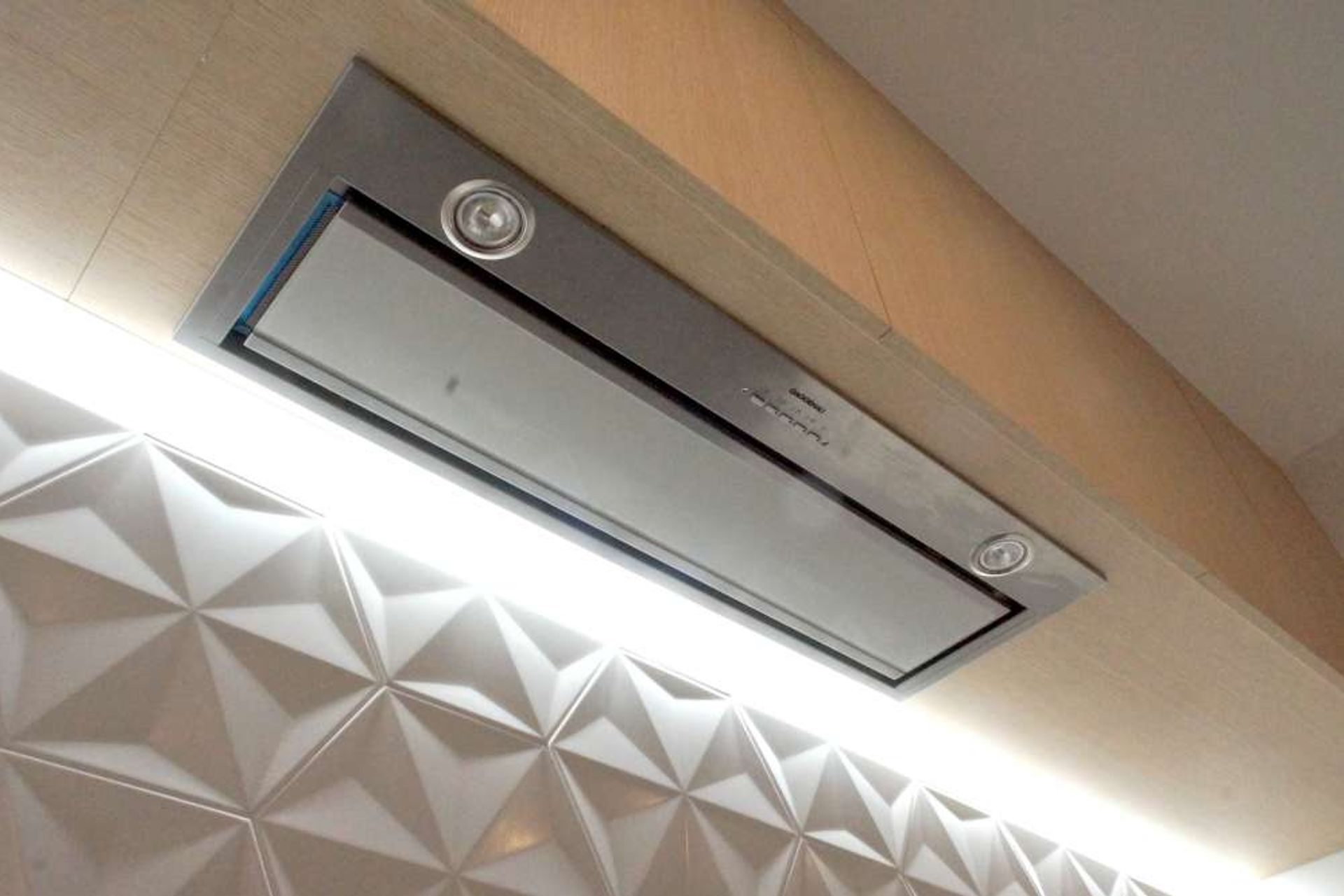 White LED lights installed below the top cabinets to highlight the backsplash and cooking range