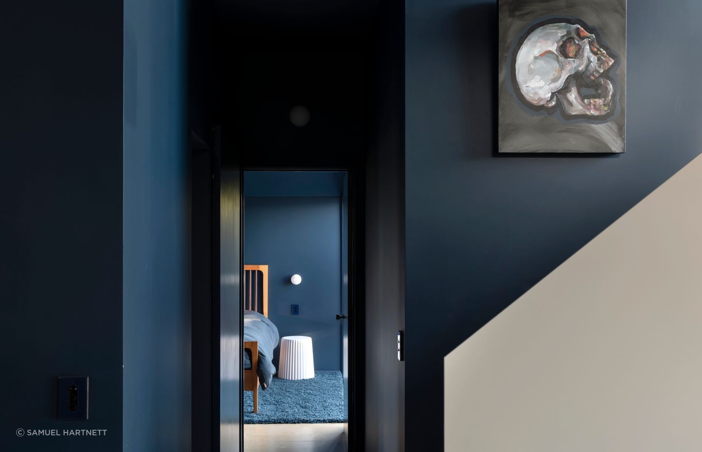 The view into the main bedroom. The bed is by Design Mobel, the rug is from iRugs and homeowner Gerry painted the artwork in the stairwell.