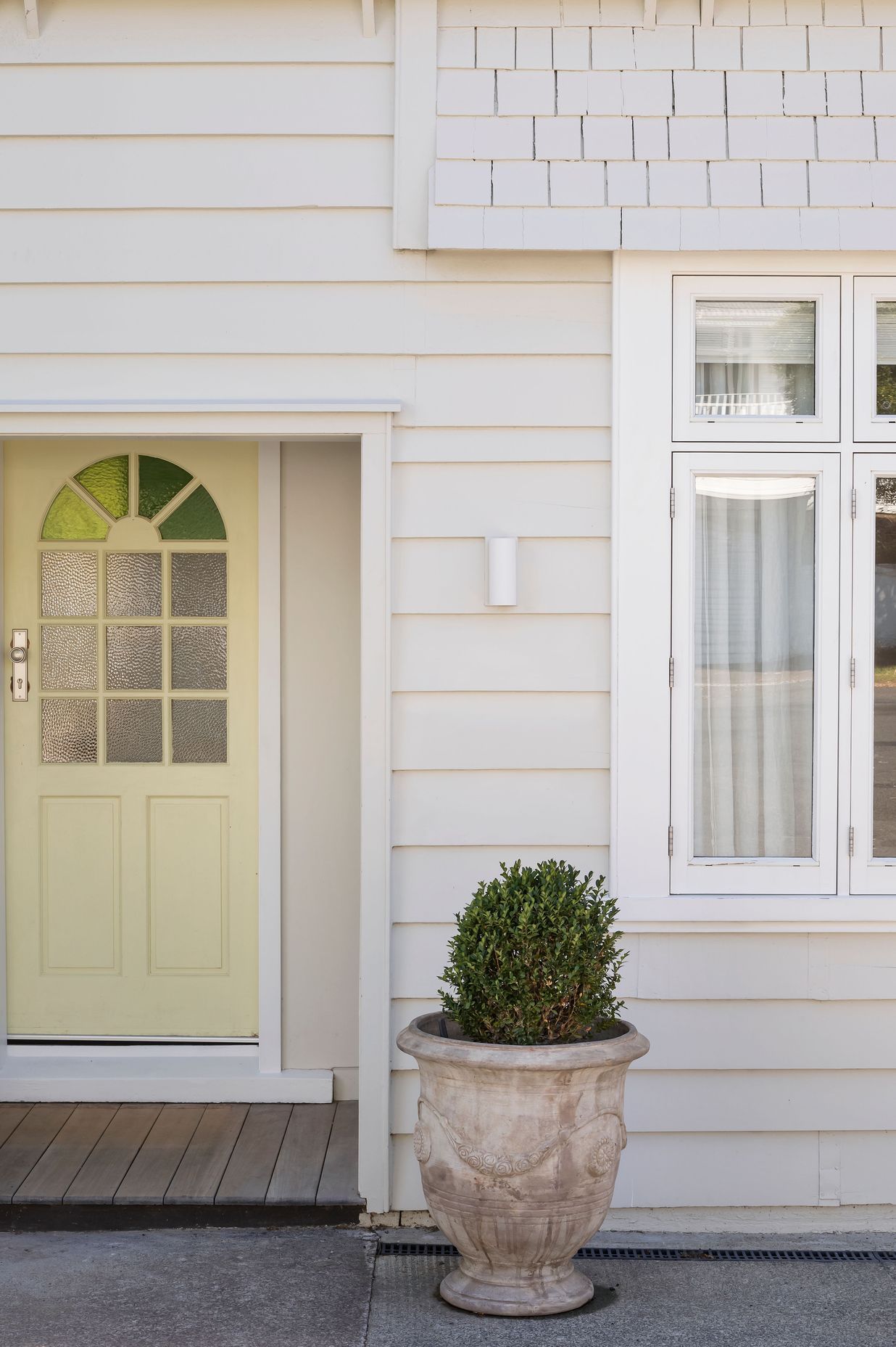 The butter yellow door adds a pop of colour to the entryway. Photo: David Straight