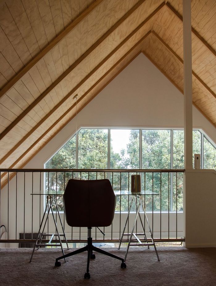 The exposed timber ceiling brings an alpine cabin feel to this Baylys Beach getaway.