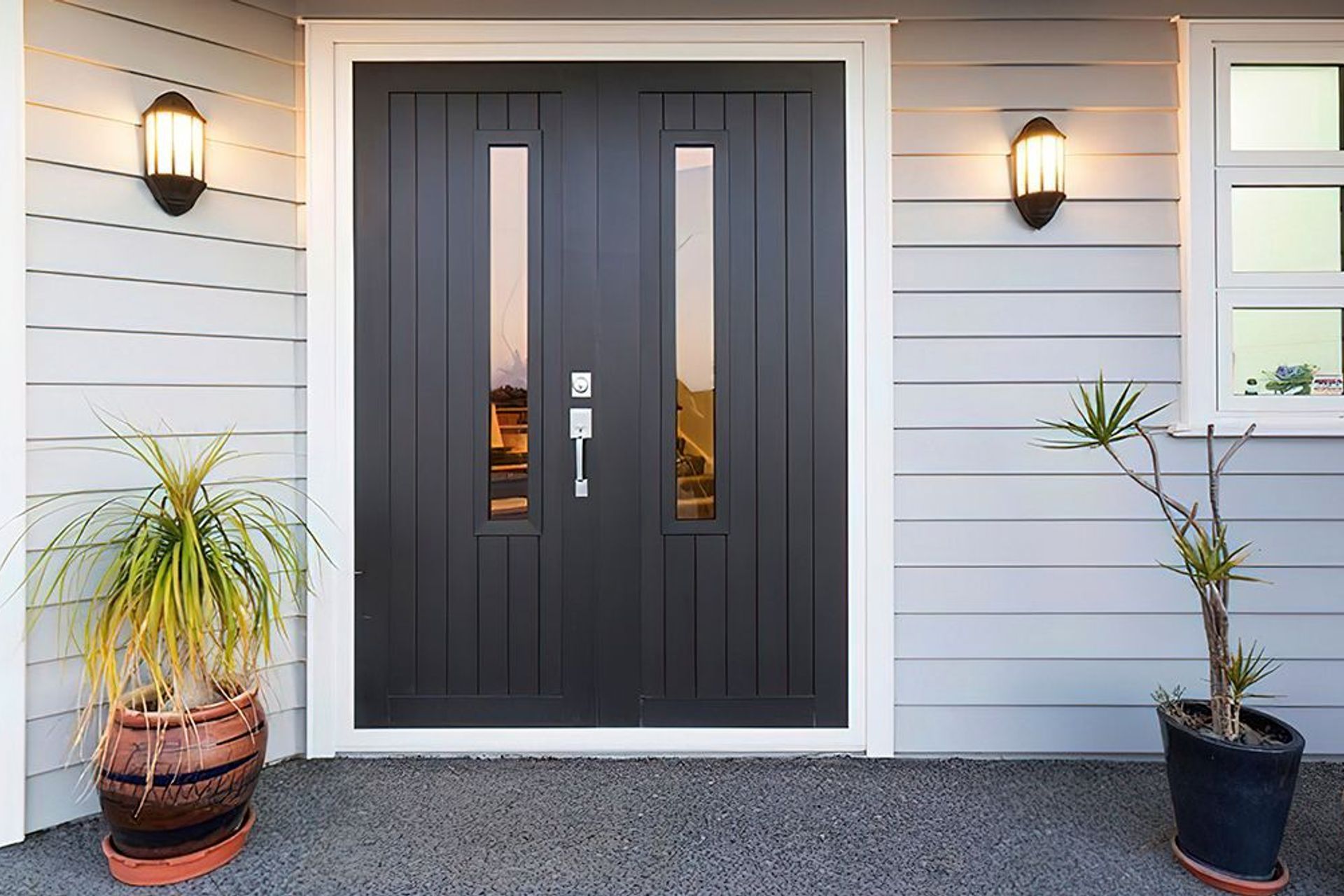 Wall sconces add illumination and style to this front door entrance area featuring the Latitude Entrance Doors