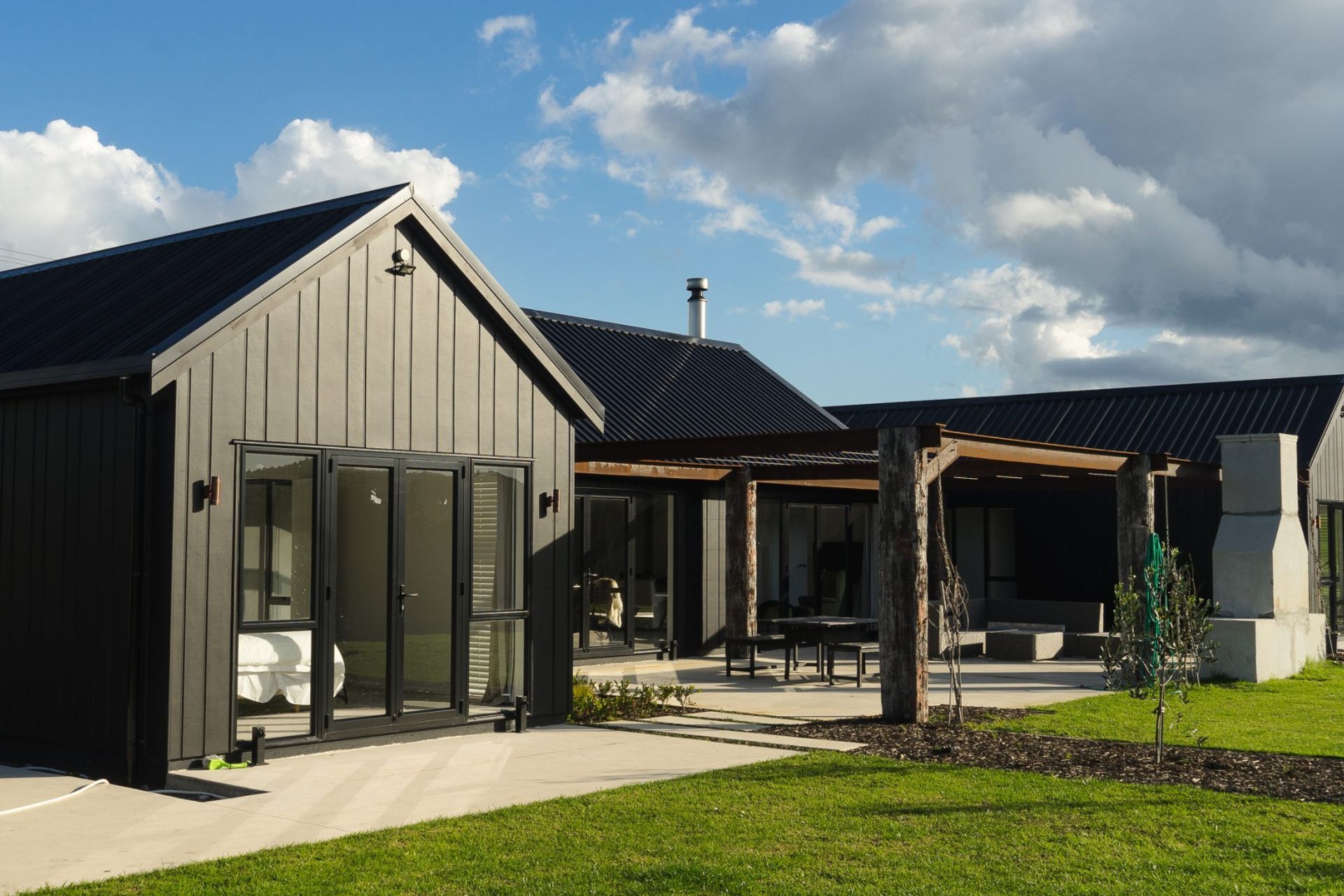 A gable roof and sleek black cladding defines this Otaika Valley home on its sprawling lifestyle block.