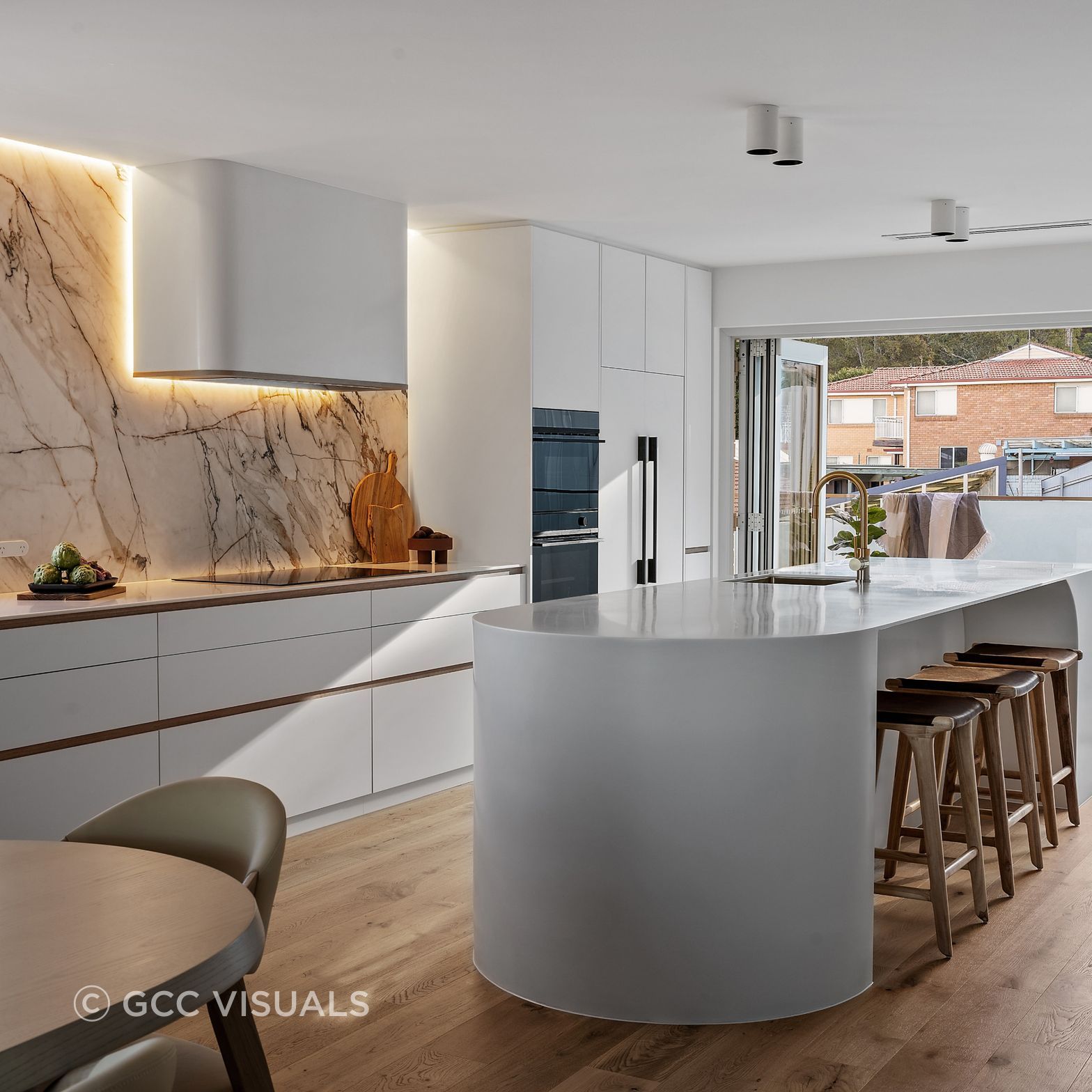 The Avenue. A coastal inspired kitchen with curved island and warm layered neutrals.