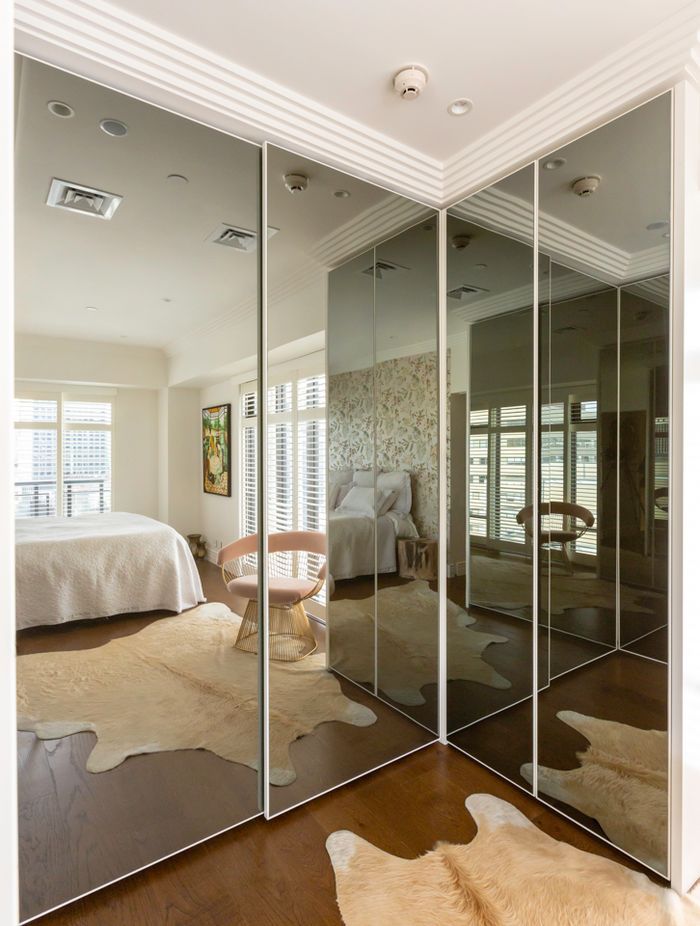 This interior by Stratford Interior Design showcases smokey glass mirrored doors, which contrast nicely against the white frames and traditional mouldings in this apartment: "This was in a very small apartment and  having that dark mirror on the wardrobes really created the illusion of space," says Gina.