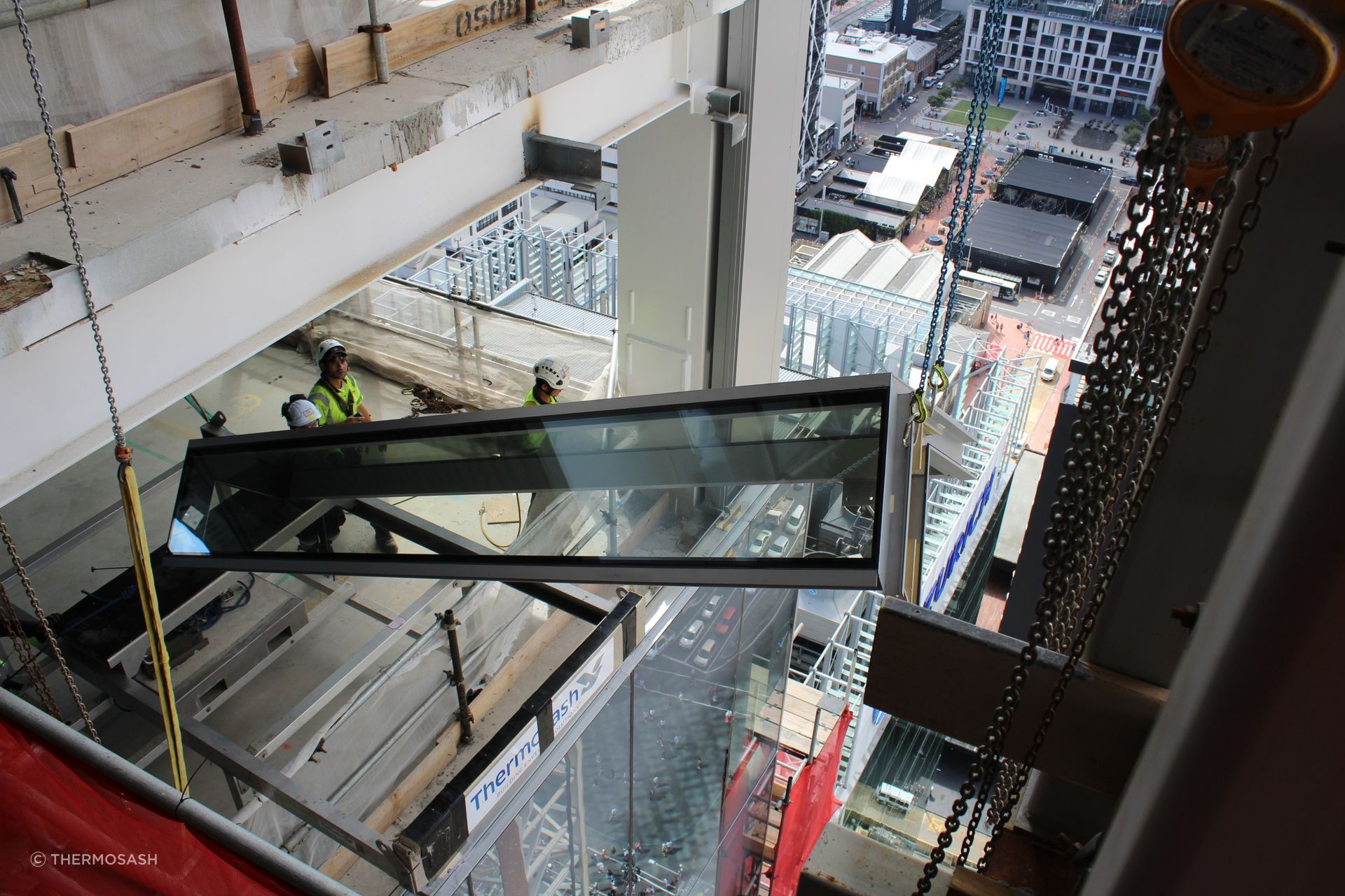 Commercial Bay Tower, Auckland - launching a curtainwall panel from height during installation of the 3183 panels on the 39-storey tower. Project stakeholders had to deal with the challenges and complexities of Covid-19 restrictions and shutdowns and CRL tunneling beneath the site.