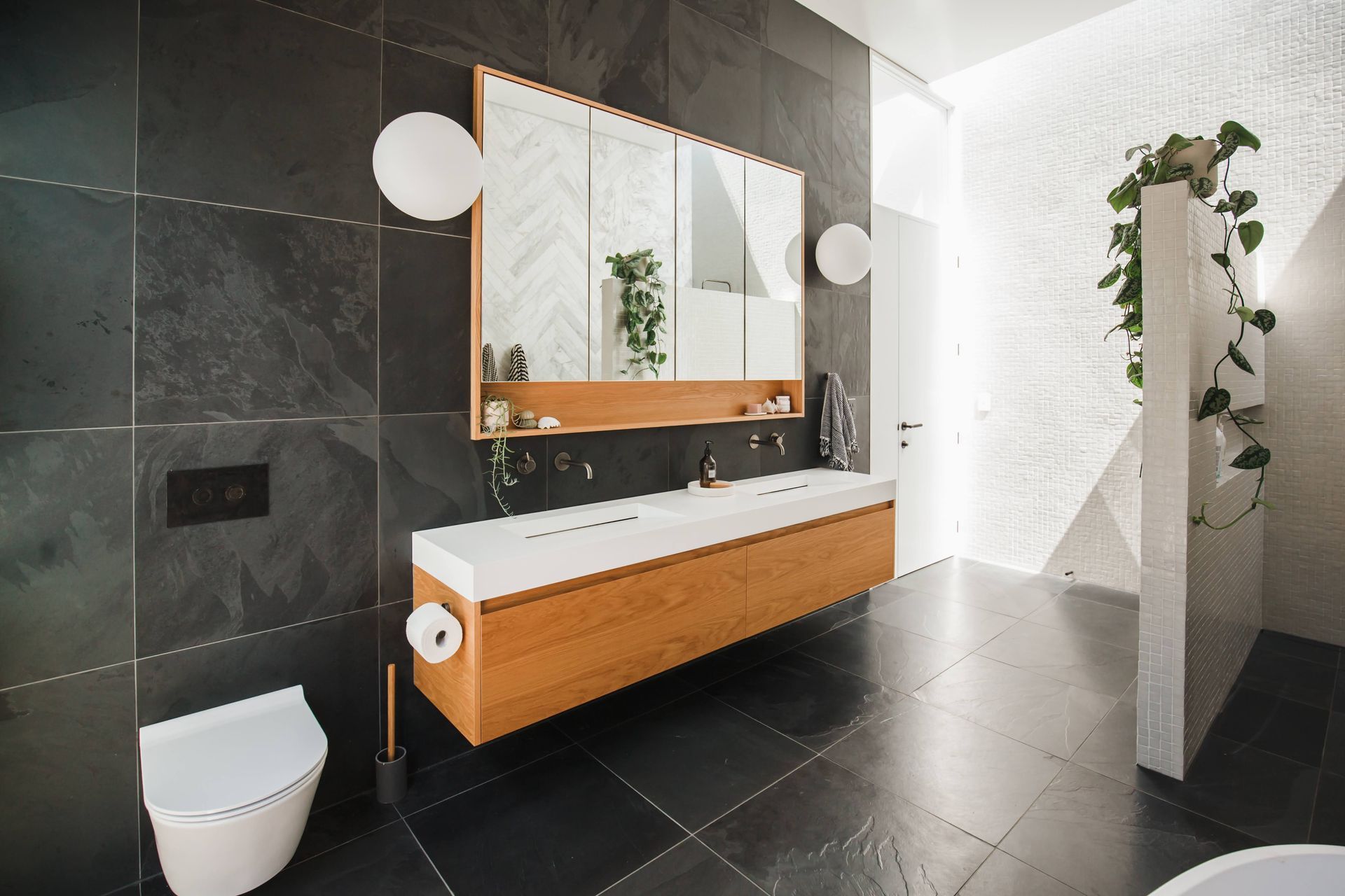 The main bathroom features a combination of slate, hone marble, and glass mosaic tiles.