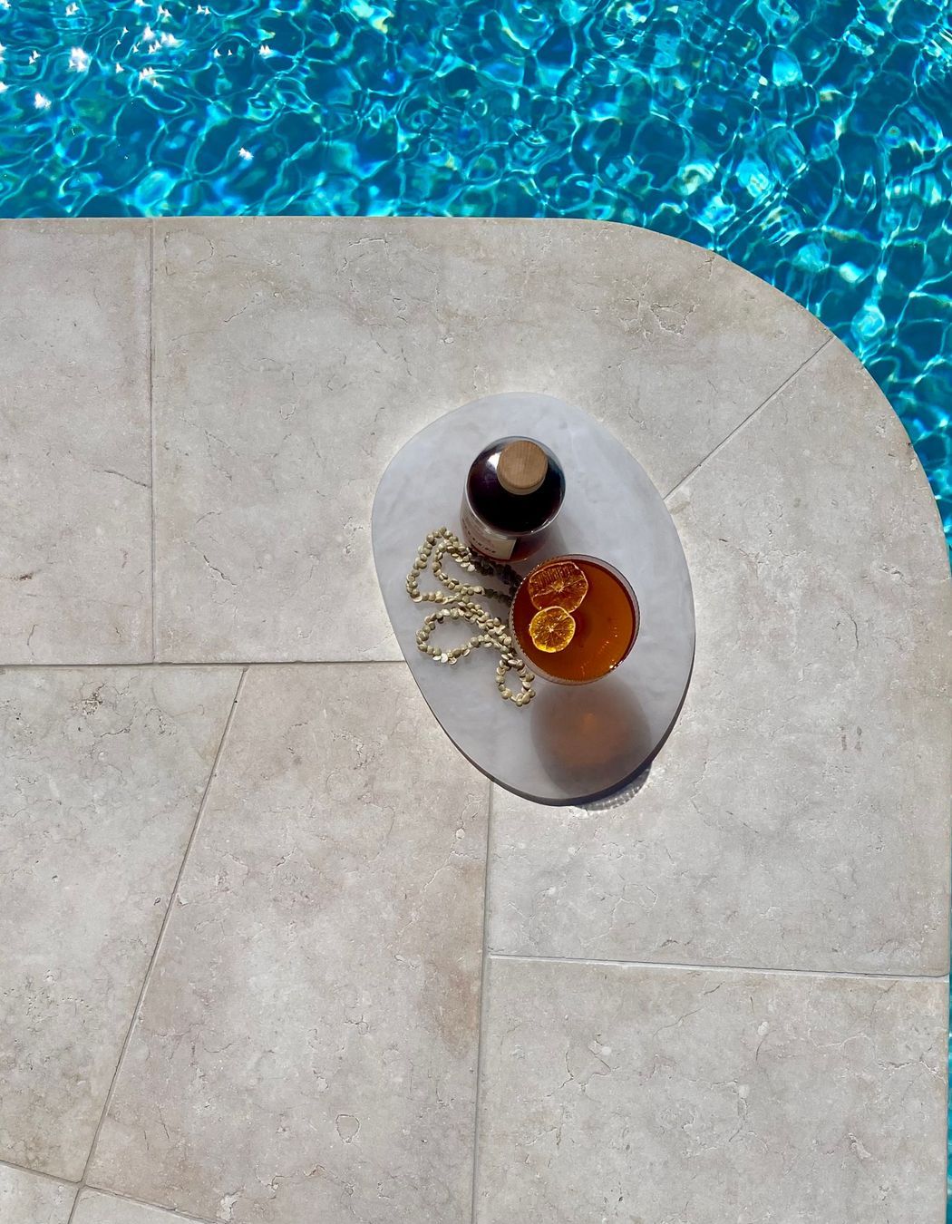 Tweed Heads Riverside Oasis by ILKA Interior Design Studio. Crema Vialle Limestone in Alfresco finish transforms this 130m² pool and spa with curved coping and precise craftsmanship by ILK Tiling. A serene 2025 outdoor retreat showcasing exceptional stone installation.