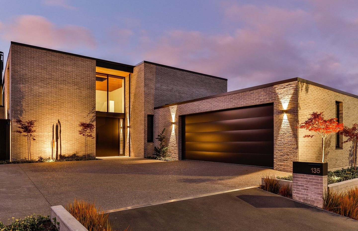 The timeless front elevation of Modern Residence, designed with a clean monolithic profile and classical brick cladding. | Photographer: Jamie Cobel