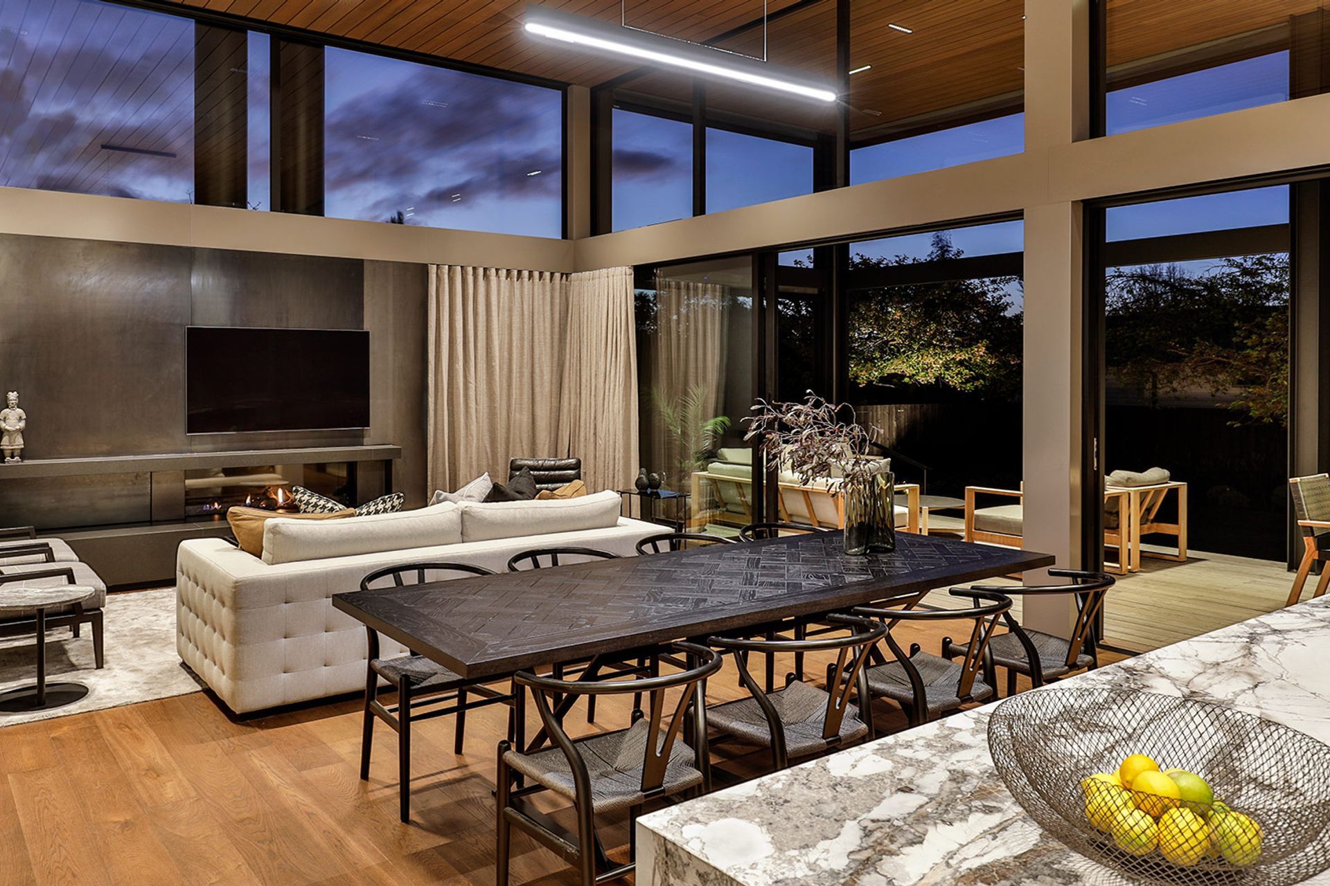 The main living area, designed with a striking feature wall and integrated fireplace made of blackened steel. | Photographer: Jamie Cobel