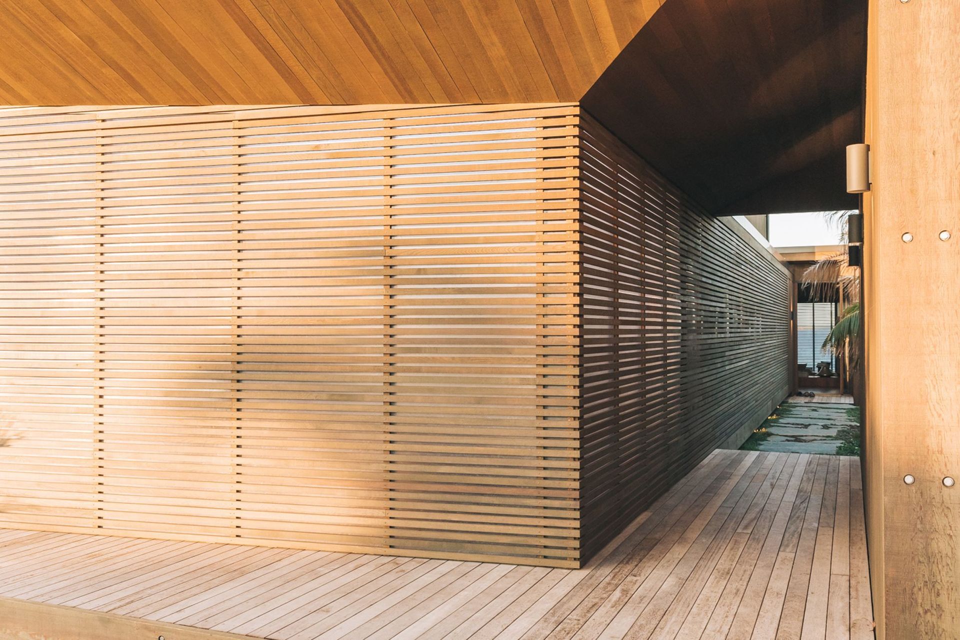 Entrance to the home is by way of a journey along a walkway that moves from decking to pavers to arrive at the front door.