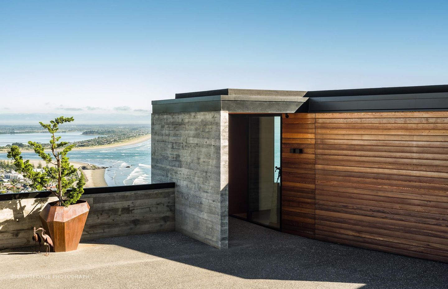 The entry from the road features a humble portal into the home, with a garage and home office located on the home's top level.