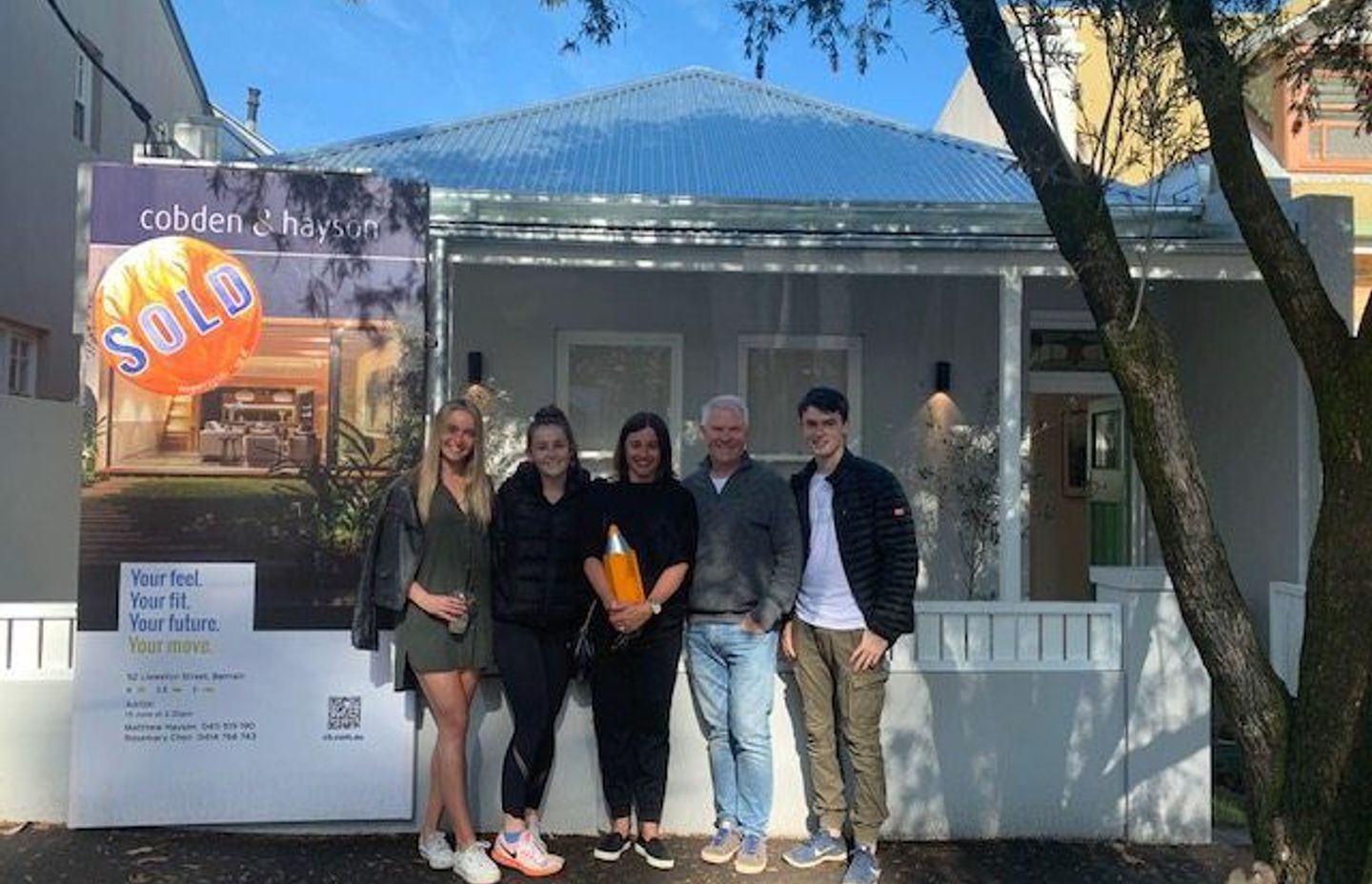 Liza and Mark Evans with their family in front of the house they bought in Balmain