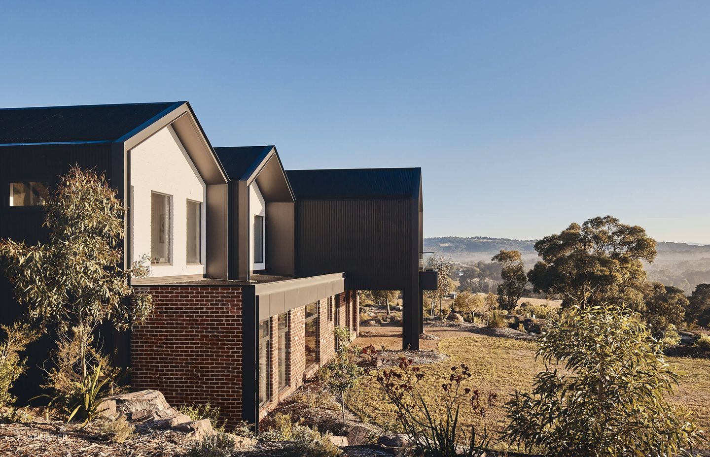 The home is surrounded by lush rolling shills and vegetation. Photography: Peter Bennetts