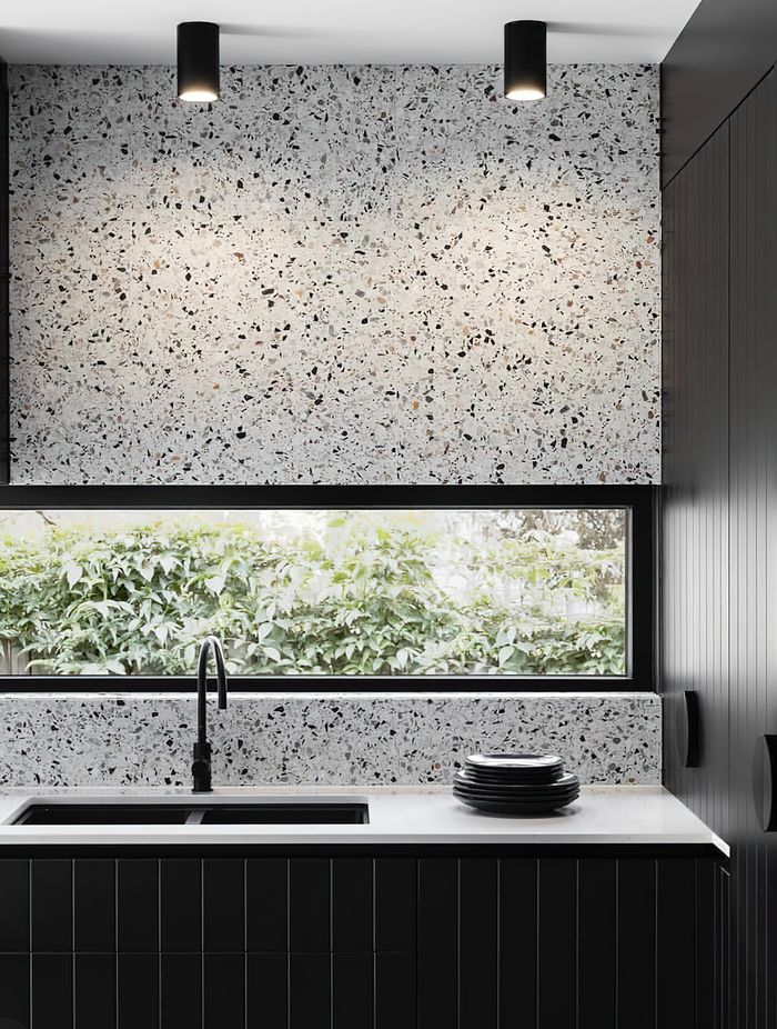 Tiles that feature a bold range of colours or patterns can sometimes feel like a challenge to pair with other materials! A great way to create a sense of cohesion and balance in your colour palette while incorporating pattern tiles is to pick out a single colour from your chosen tile and match this in other areas of your design scheme. This luxurious kitchen for example pairs terrazzo tiles with a black speckled pattern with black kitchen cabinets to create a harmonious look.