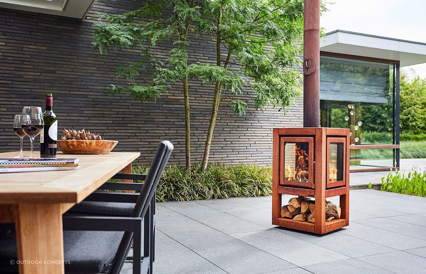 Even a small wood fire like this Quaruba fireplace can provide cost-effective heat outdoors. 