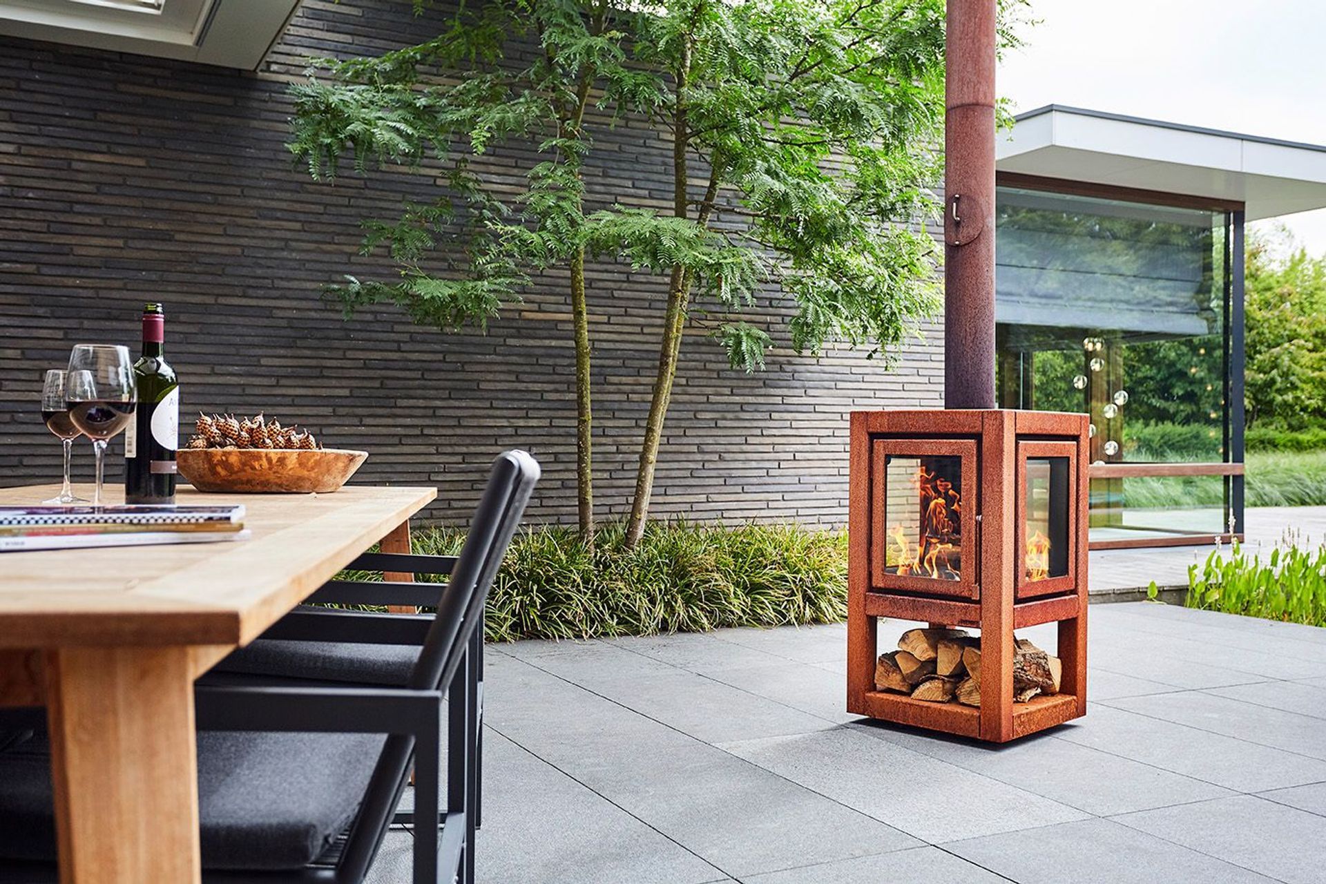 Even a small wood fire like this Quaruba fireplace can provide cost-effective heat outdoors. 