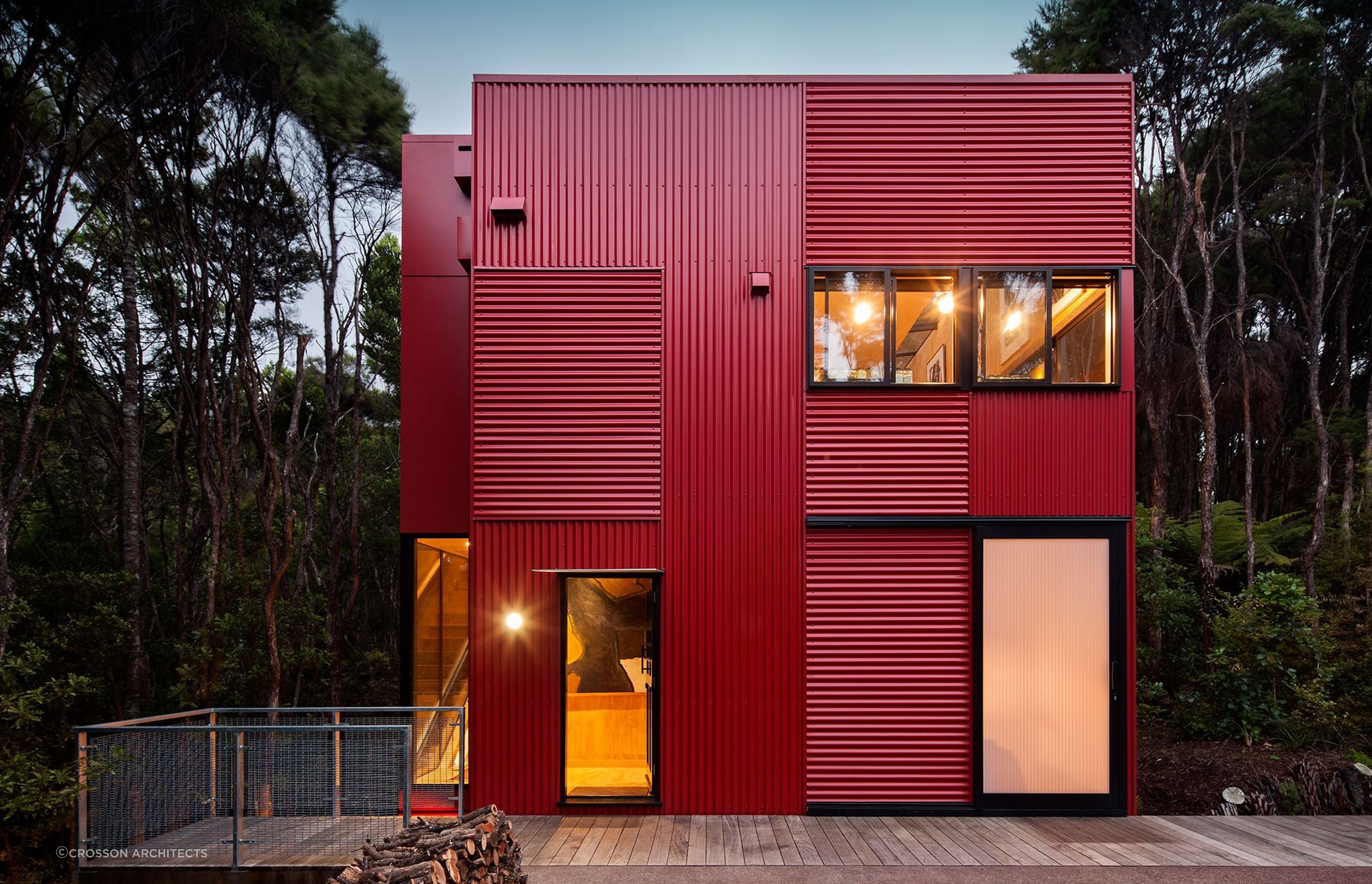 Red-painted corrugated iron makes this house pop in it’s green bush surroundings.