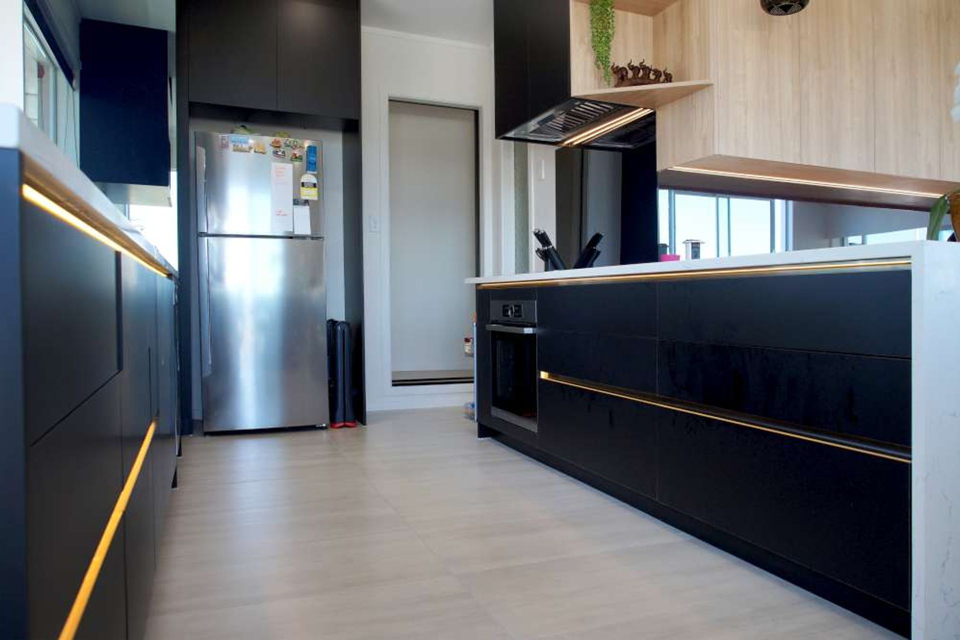 Kitchen renovation in West Auckland Massey - Our client in Massey wanted black cabinets against white to give a luxurious feel to his kitchen. LED lights were also installed under the cabinet handles to add to the glamour of the kitchen.