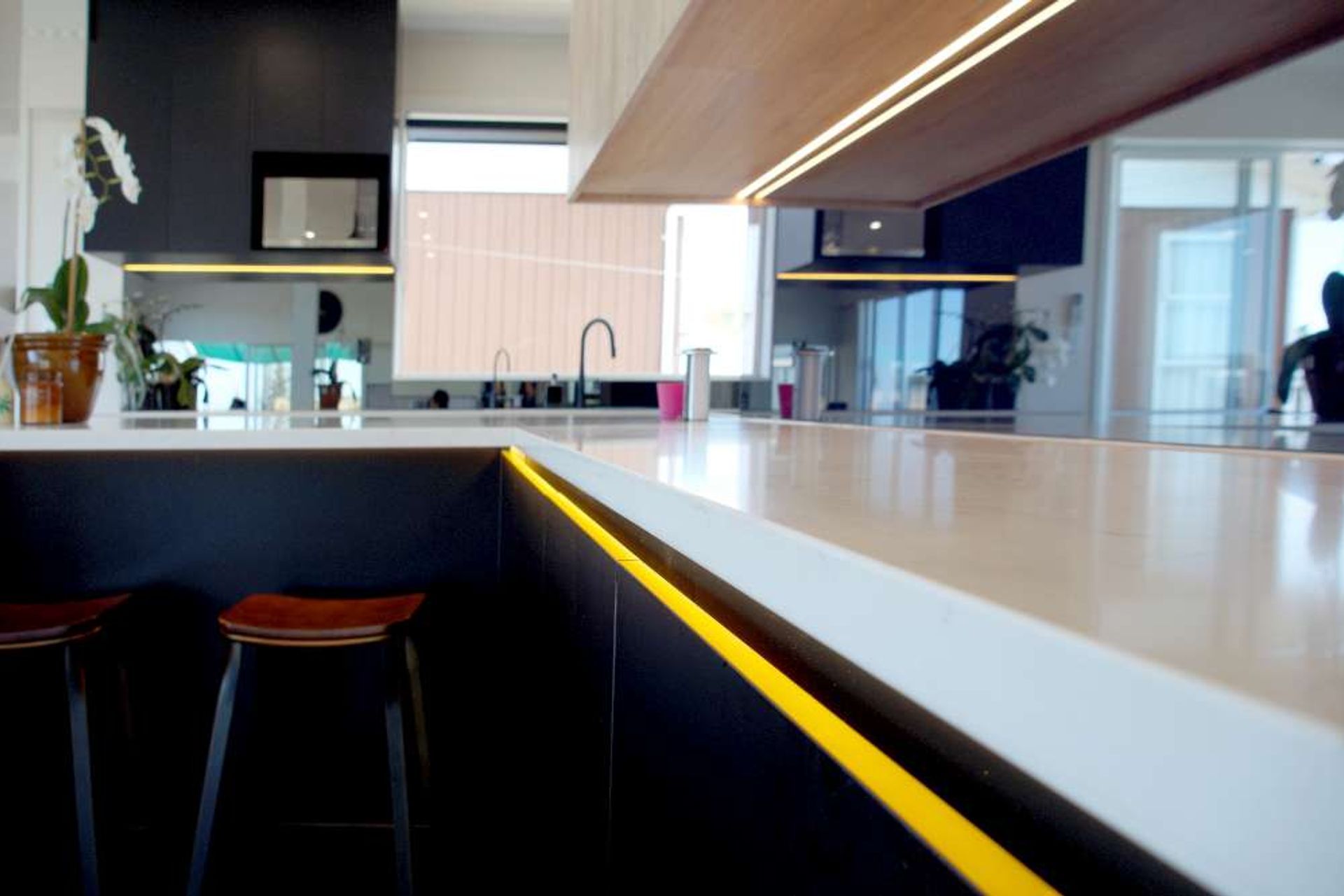 Yellow LED lights installed below the countertop which provides a great contrast to black cabinets