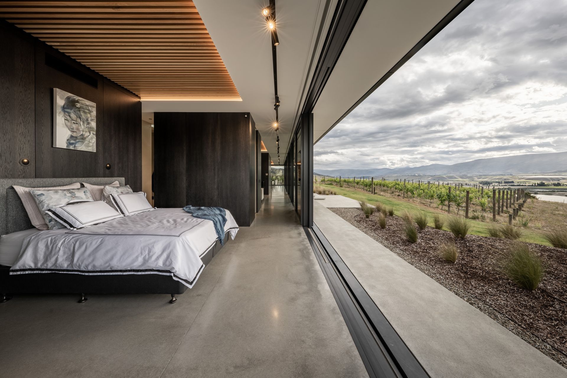 The main hallway running along the face of the western pavilion, from the master suite, past the media room, and down to the kitchen. | Photographer: Simon Larkin