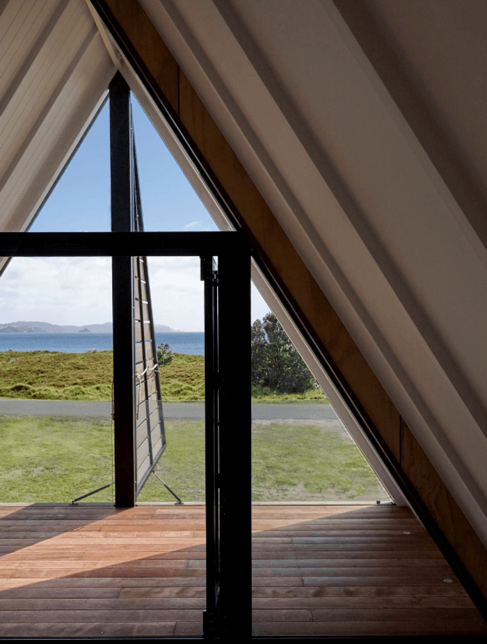 Upstairs, the architect's favourite spot in the house is the covered deck in the triangular master bedroom space, with its dormer shutters that open to reveal the view. A glass balustrade is almost invisible.