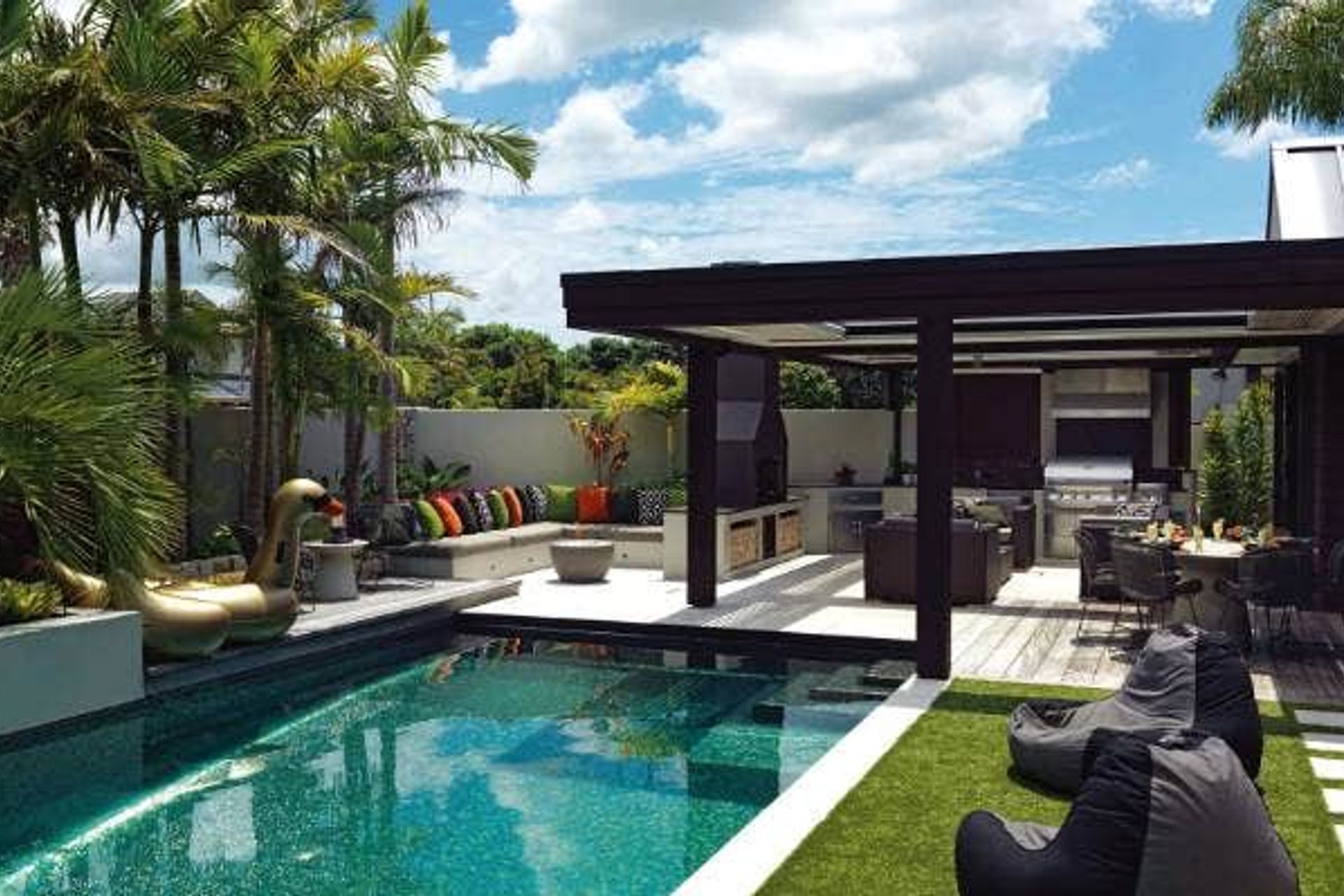 Stuart and Rachael McNall made the most of every part of the outdoor area of their Auckland home by dividing it into zones that are delineated by the use of different materials; they use it year-round, thanks to the louvred roof, three outdoor heaters and the fire; Stuart wanted the purple heart decking to look like a wharf, so it's made with thick 50mm planks.