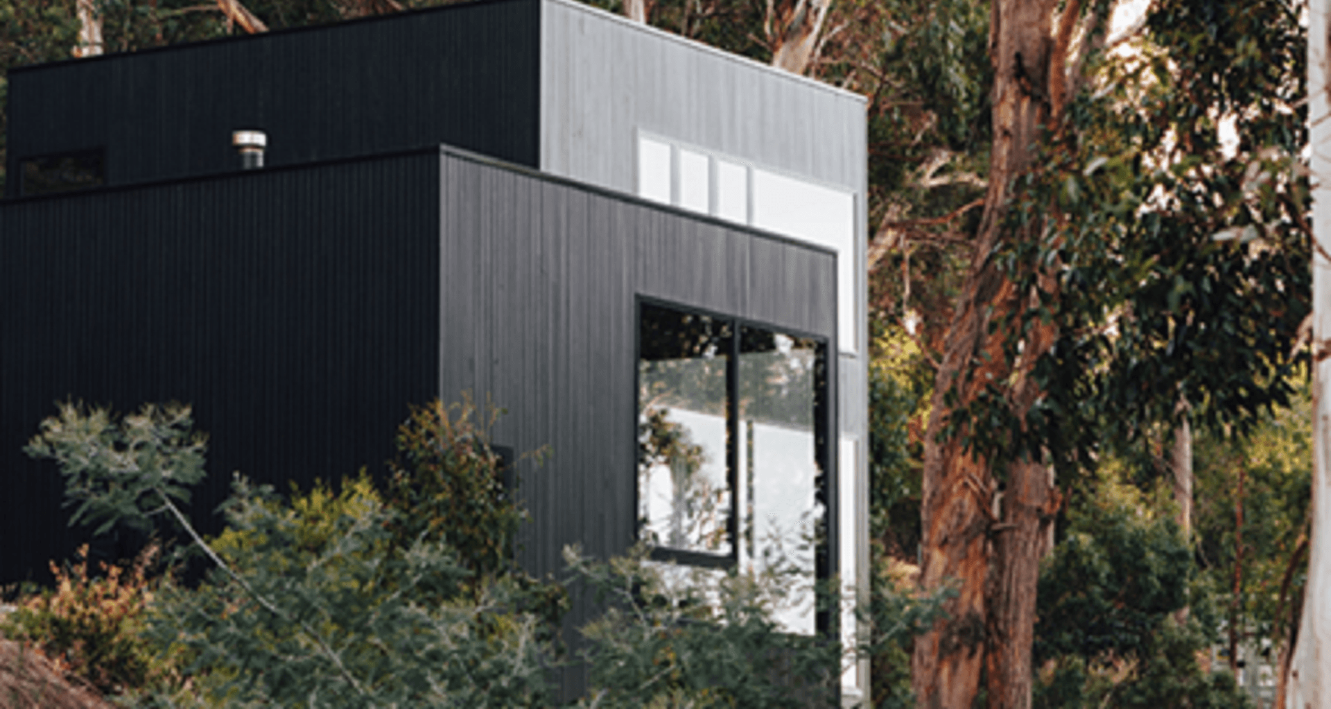Consisting of two linked timber clad pavilions coated in Palm Beach Black. The property looks over the Derwent River and rooftops of central Hobart. Photograph: Emily Weaving.