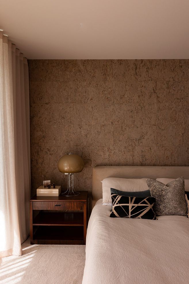 The cork feature wall brings warmth and texture to the bedroom.