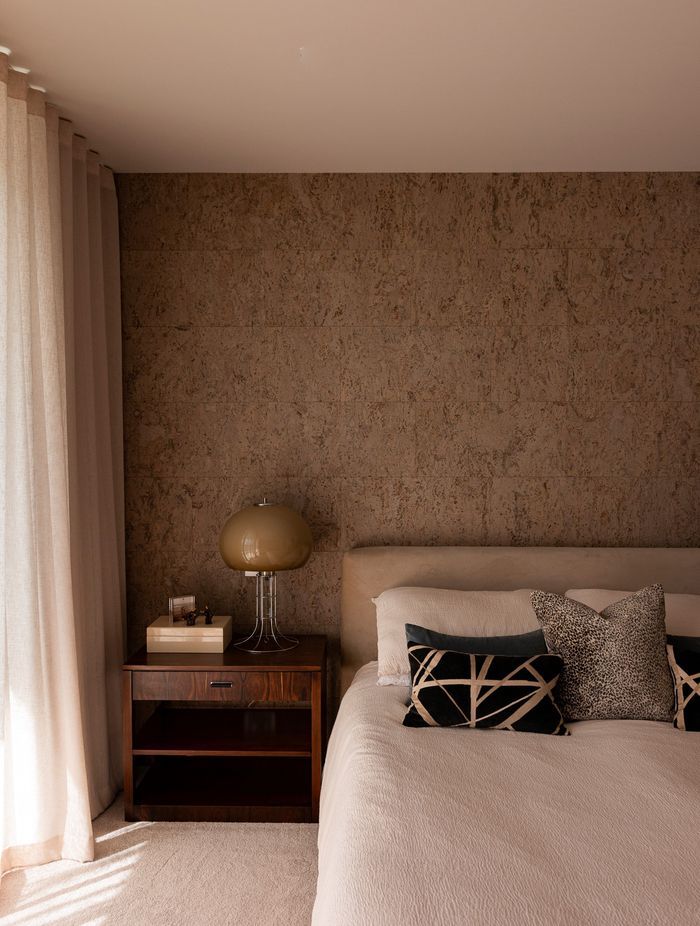 The cork feature wall brings warmth and texture to the bedroom.