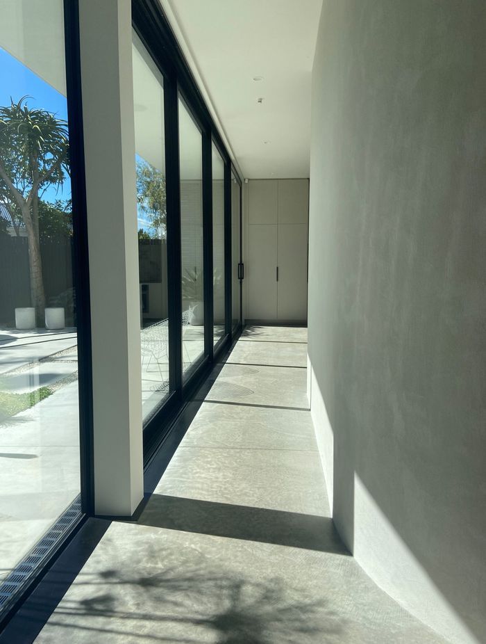 The gentle curve of the hallway wall guides you into the open-plan kitchen, dining, and living space.