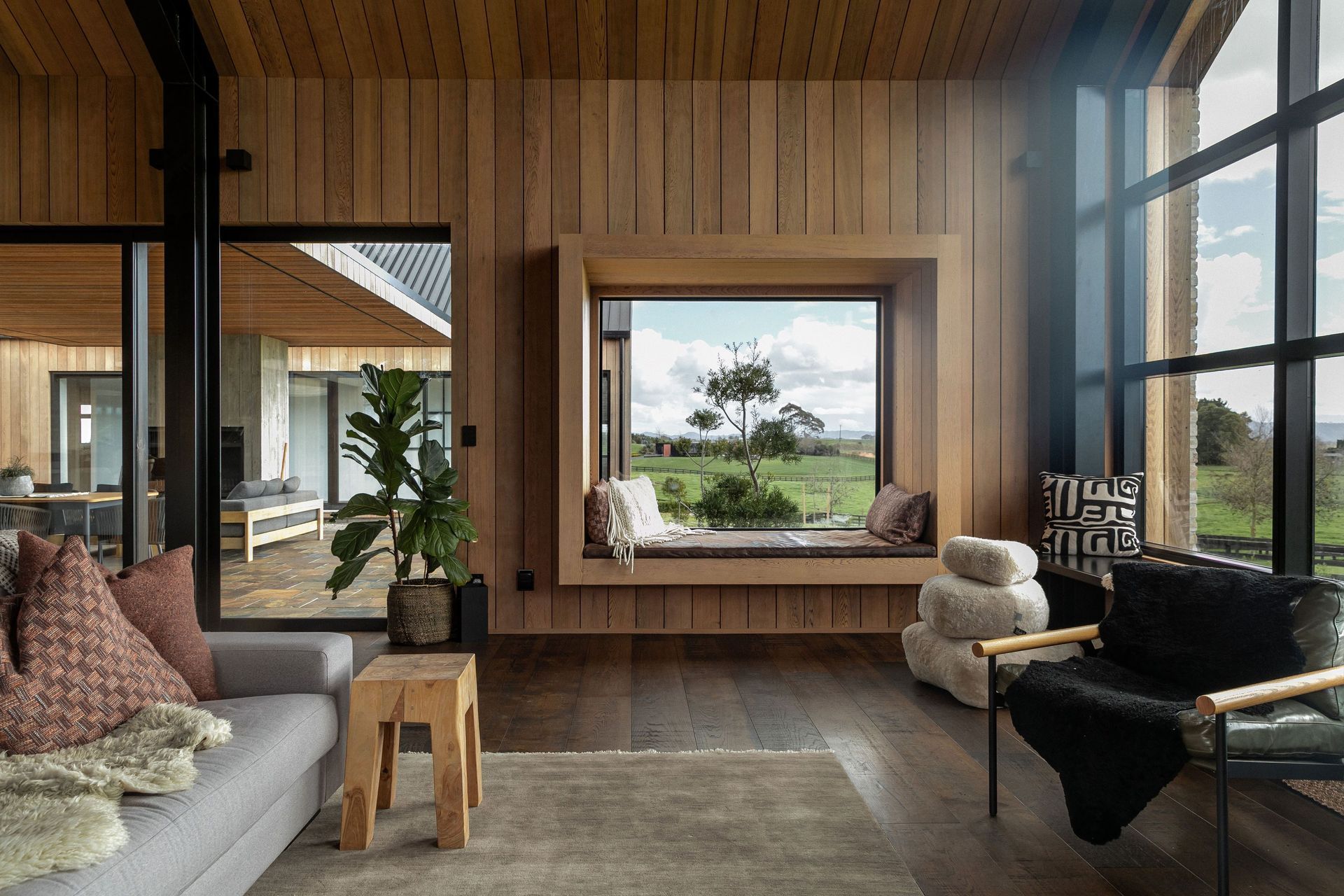 The living space sandwiches an outdoor courtyard between it and the guest wing; a picture window with built-in seating is the perfect spot for reading.