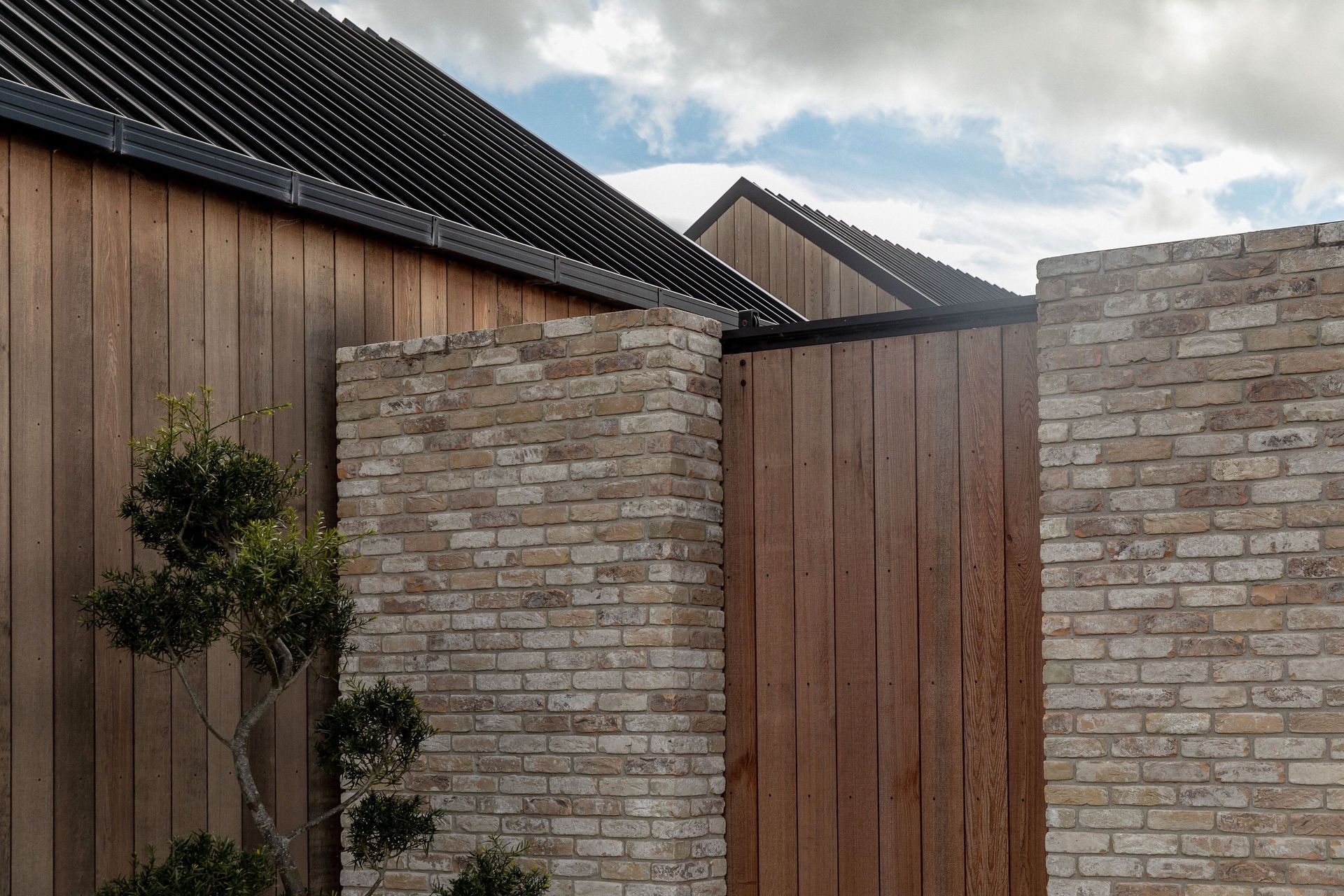 The juxtaposition of cedar, black steel and pale brick forms a rich exterior materiality.