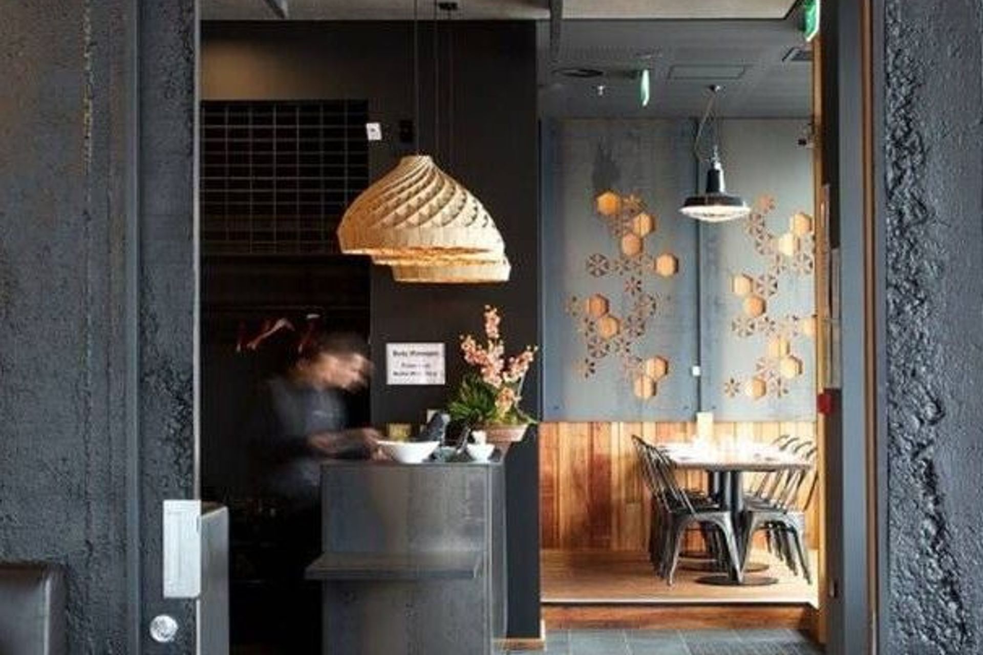 Spice Paragon Restaurant in Christchurch features Muros Grey Roughcast Concrete wall panels installed vertically and painted in Resene All Black. Design by Crafted.