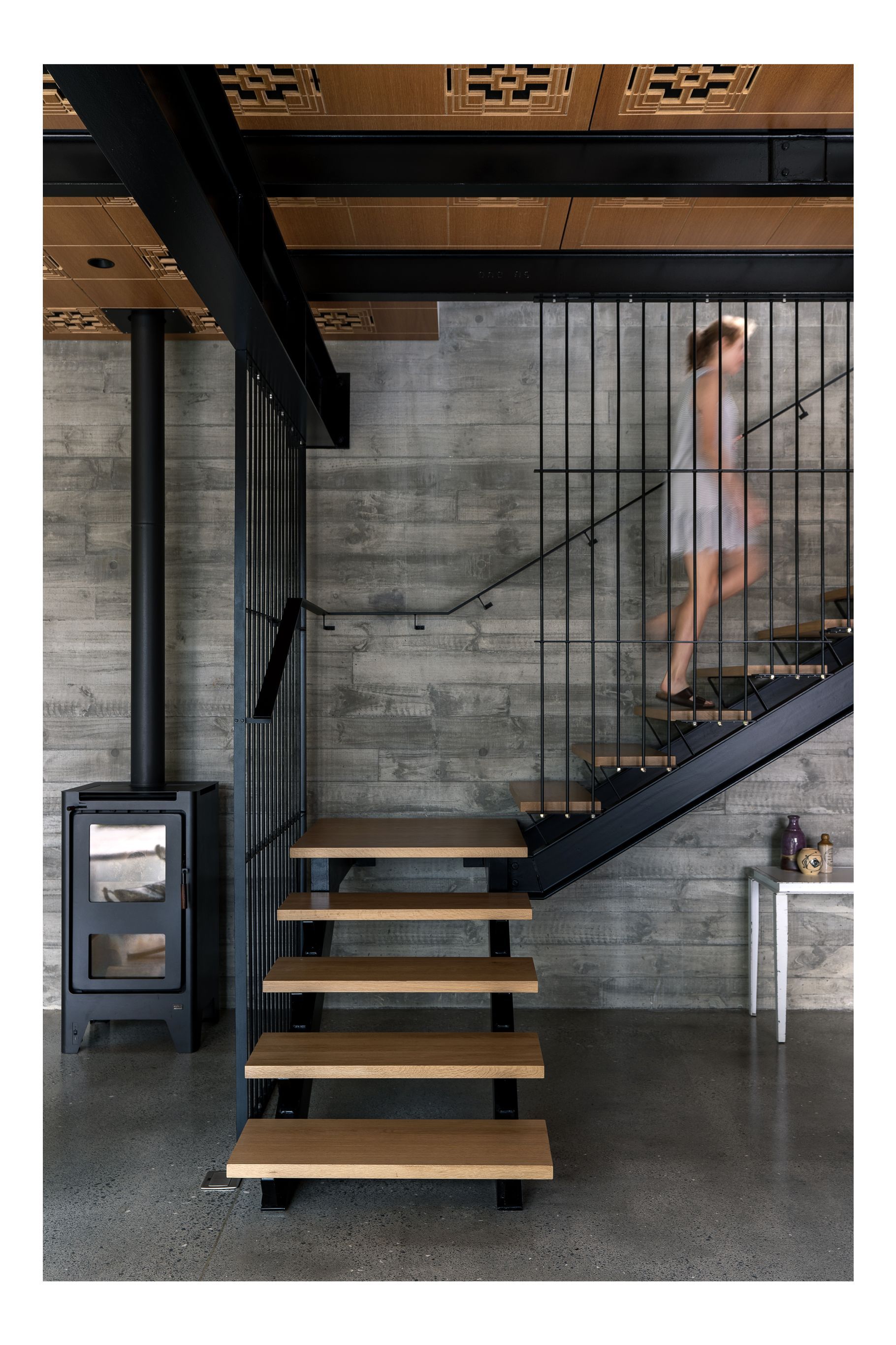 “That fireplace basically heats all of this area. We do have some ducted heat pumps. But to be honest, in the summer, we leave all the windows open and don't need it and in the winter, we light the fireplace at five o'clock and it heats the house all evening.” Clive has collected some second-hand furniture. “I like something that's got a little life to it. It's got a history rather than something brand new.” The Michael Draper table under the stairs was bought when he closed down his factory. “So I've just cleaned all the grease off it, and we've had it for years. I keep putting it into whichever house we live in.”