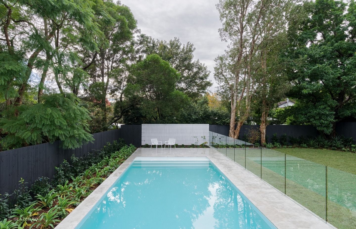 Glass fences can provide a stylish contrast to traditional wood fencing panels. Featured project: Warrawee Residence.