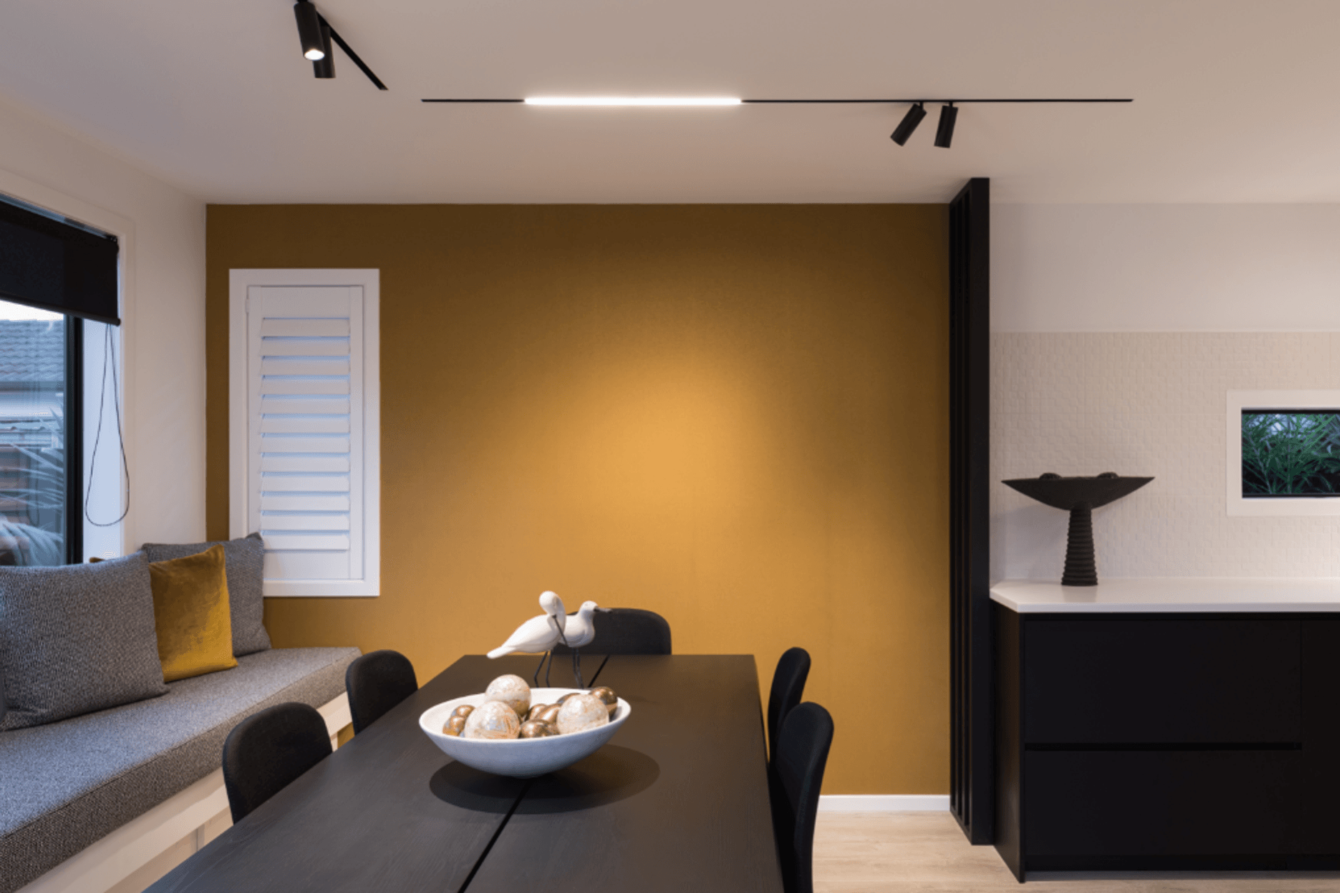 The sophisticated use of track lights in a dining room, featuring the Move It Trimless Low-Voltage Lighting Track from Lightplan.