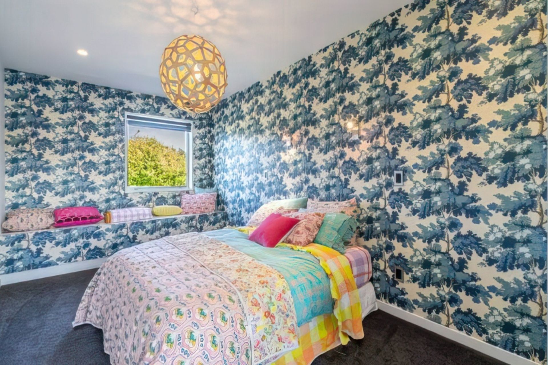 The bedroom is as colourful as the rest of the home, with pinks, blues and oranges completing the look.