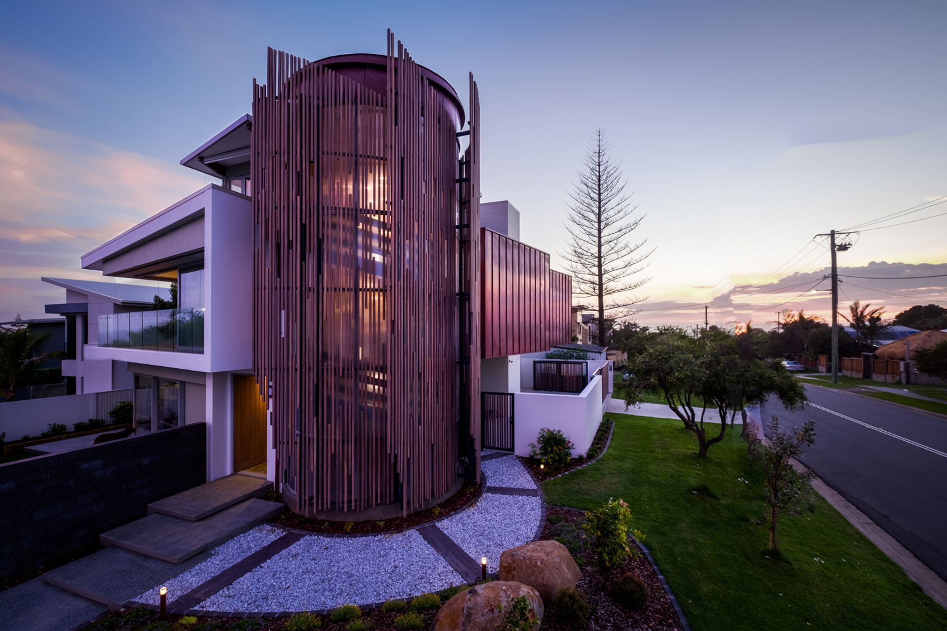 The wooden slats encasing the staircase act as a dramatic light filter.