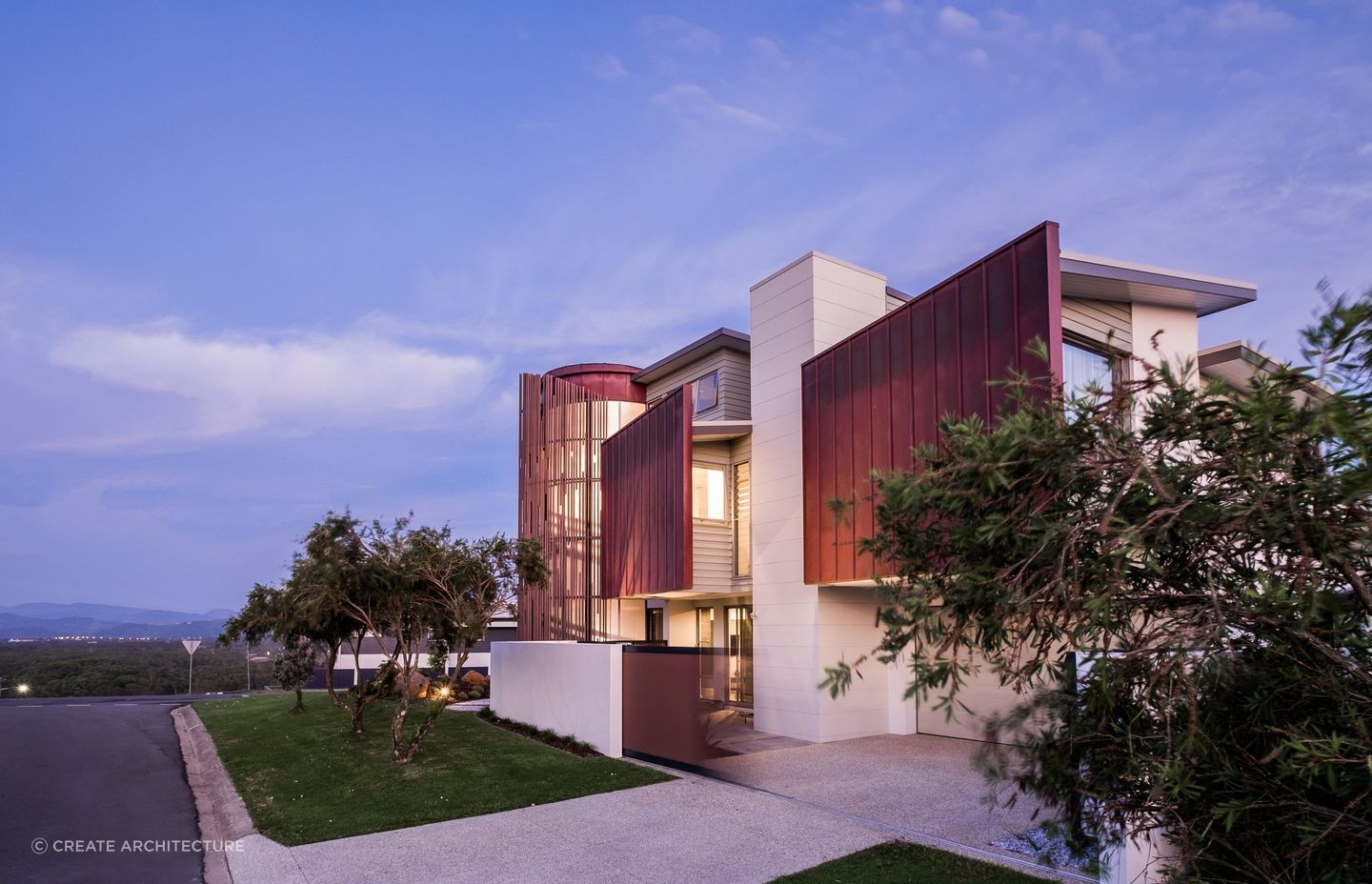 As dusk falls, the home's weathered metal panels, stands out against the gentle evening sky.