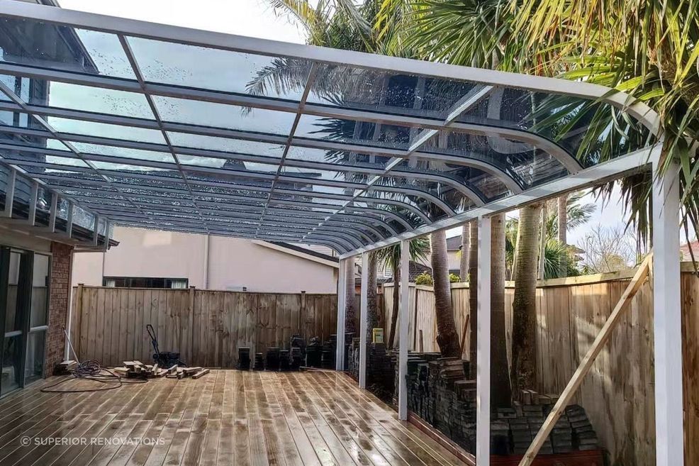 A white custom pergola over a deck with UV protective panels on top