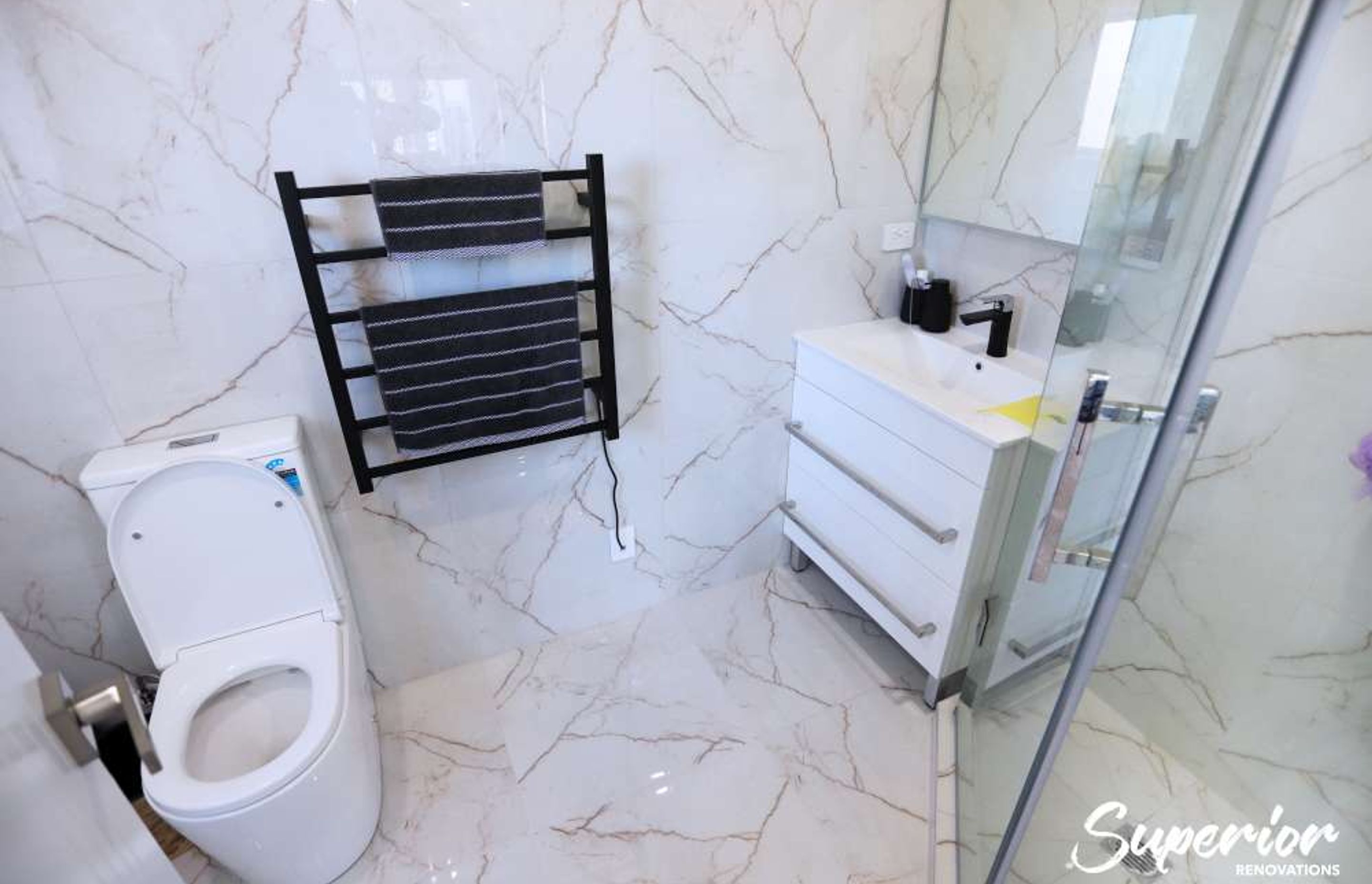 This was a very small awkward place but our clients wanted to make this a guest ensuite. We used the corner L shaped area to make a tiled glass door shower. The same times were used on the walls and floors to give an illusion of space – Bathroom renovatio