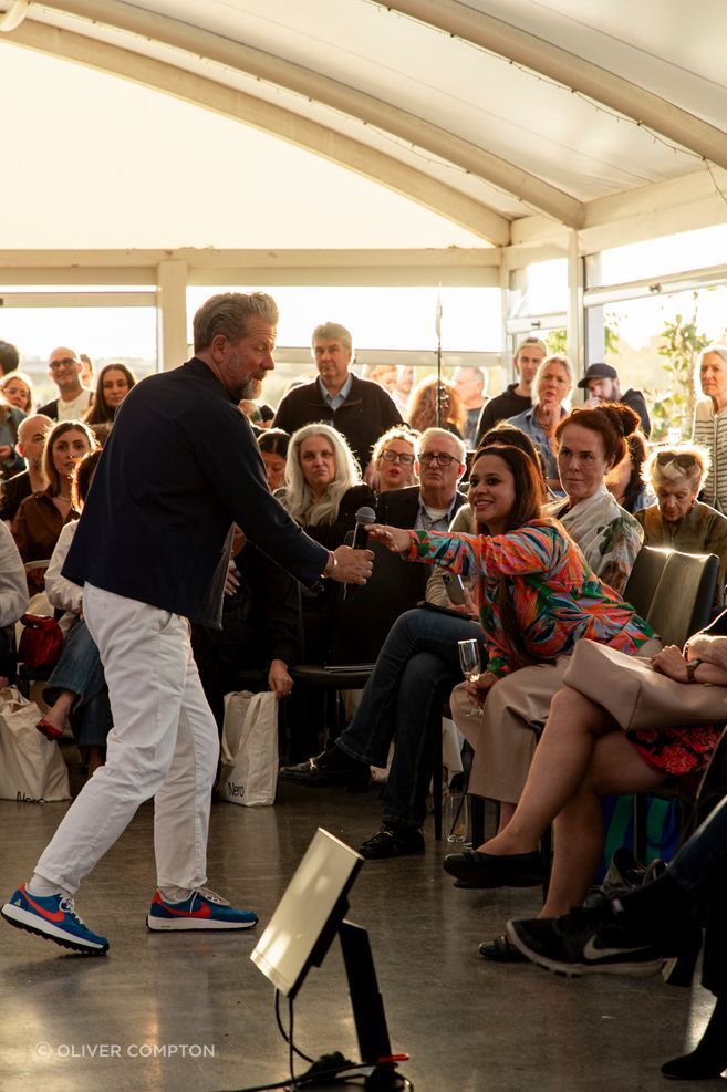 Tim Ross handing the microphone to an eager audience member during the Q&A part of the panel discussion.