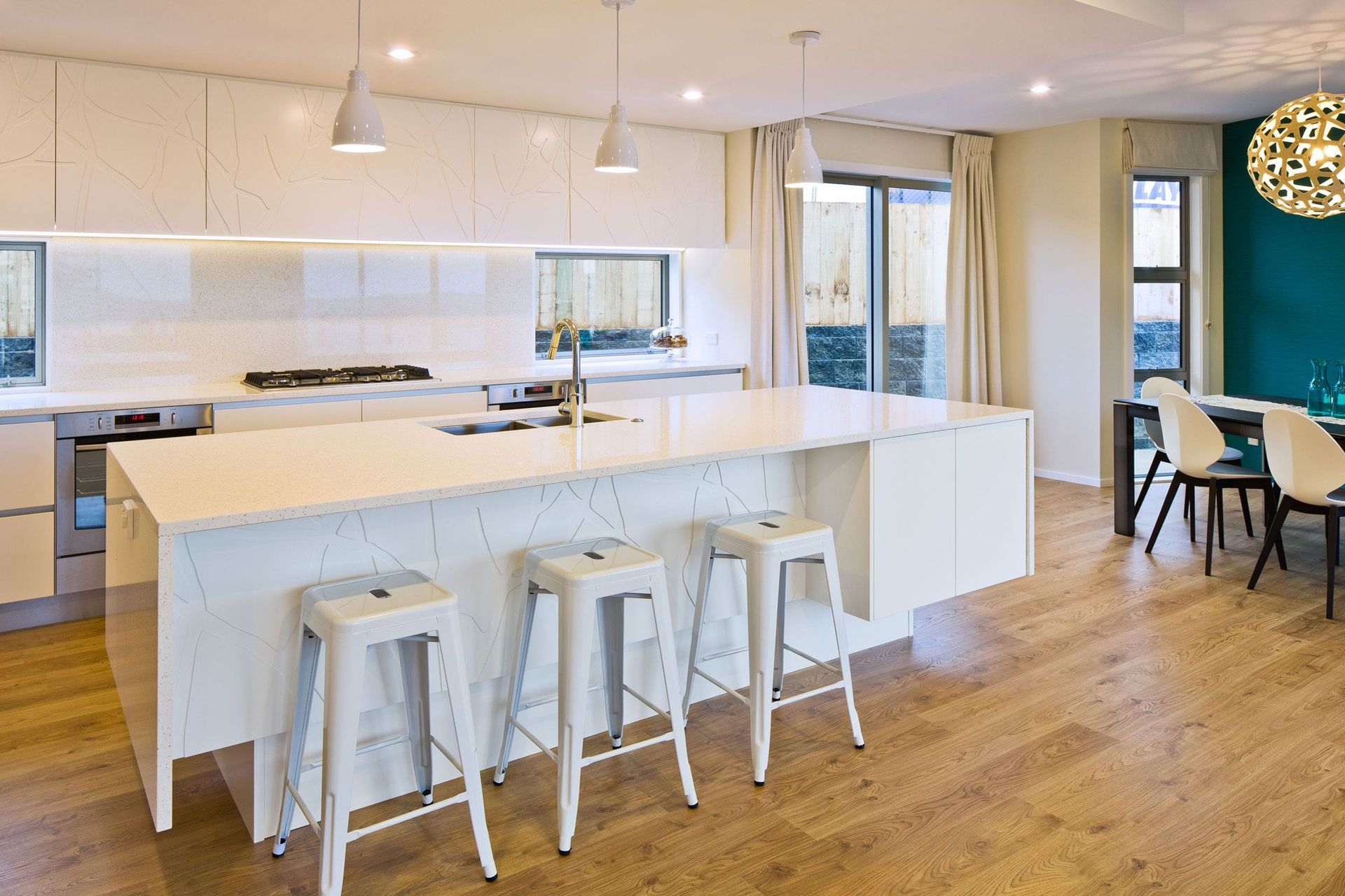 To bring something unexpected to this white kitchen, Simone worked with the joinery team to add a unique tree pattern to the cabinetry – adding textural interest.